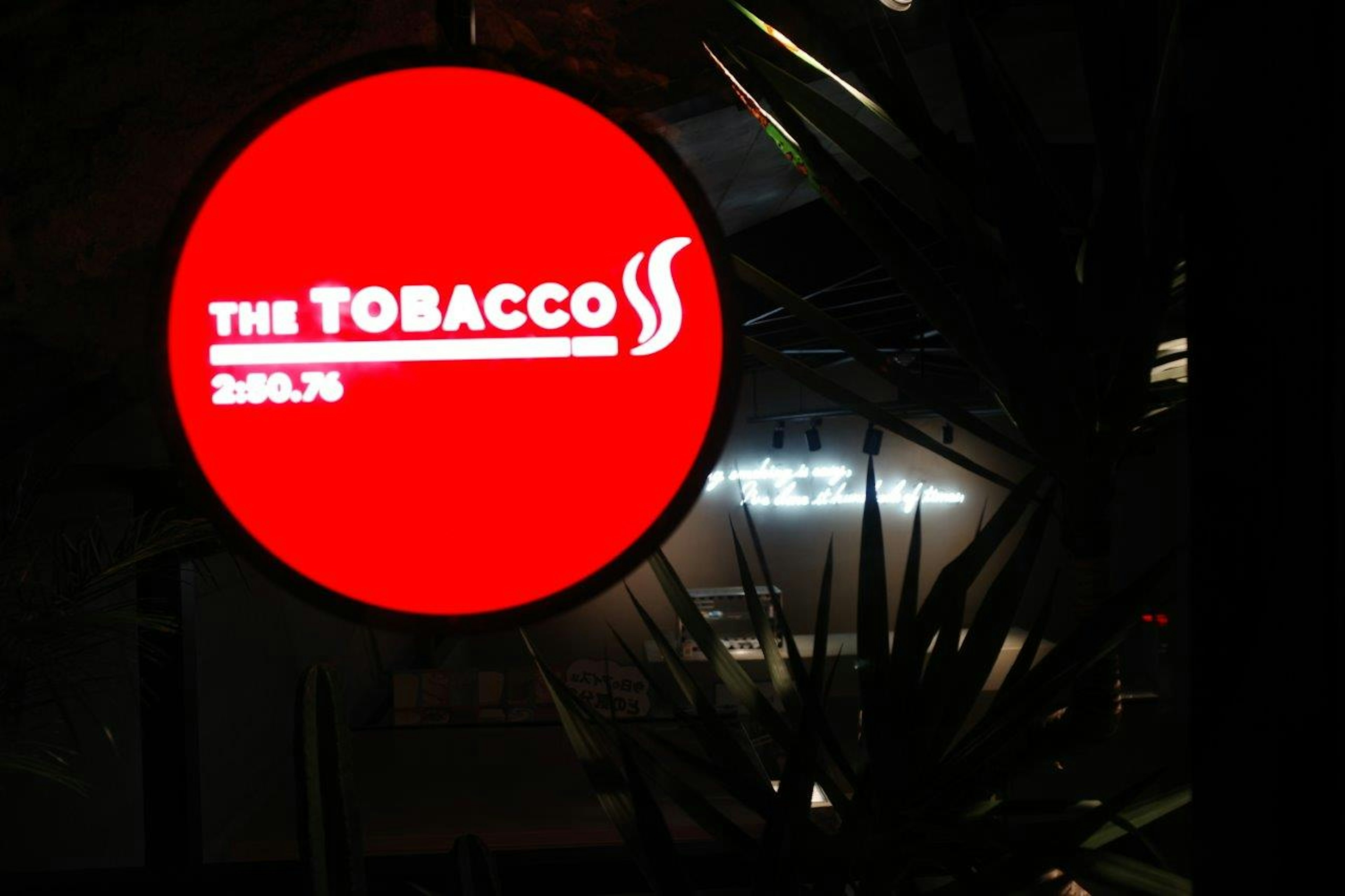 Ein runder roter Schild mit weißem Text, der THE TOBACCO liest