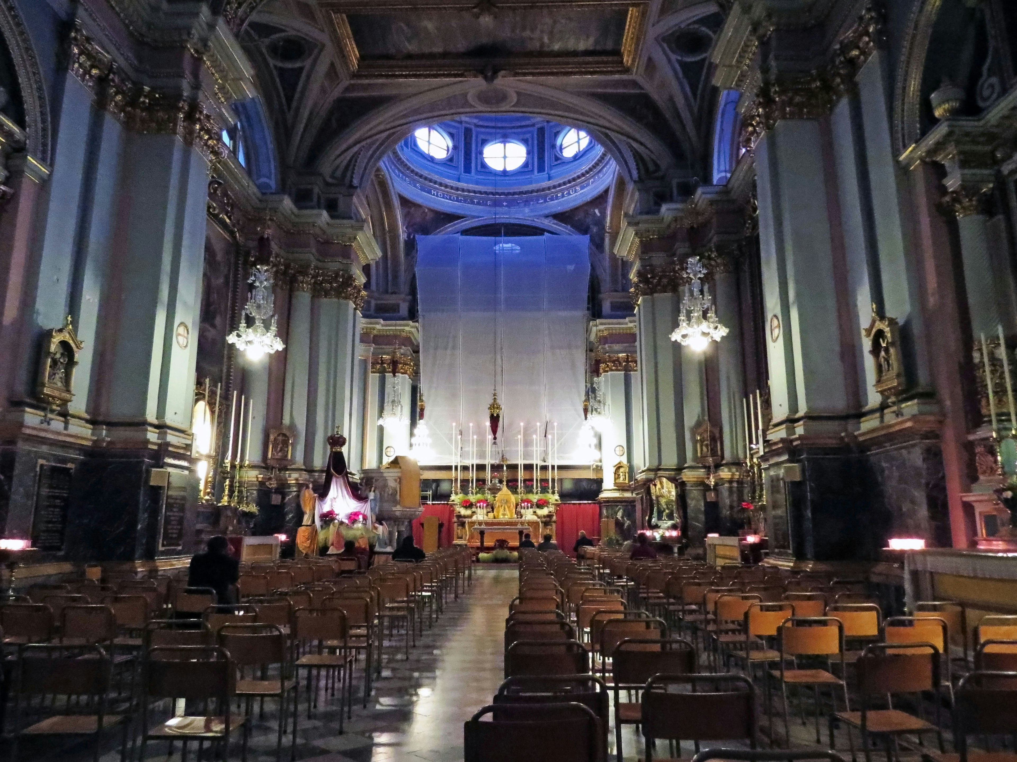 Interior of a cathedral featuring high ceilings and beautiful decorations with rows of chairs