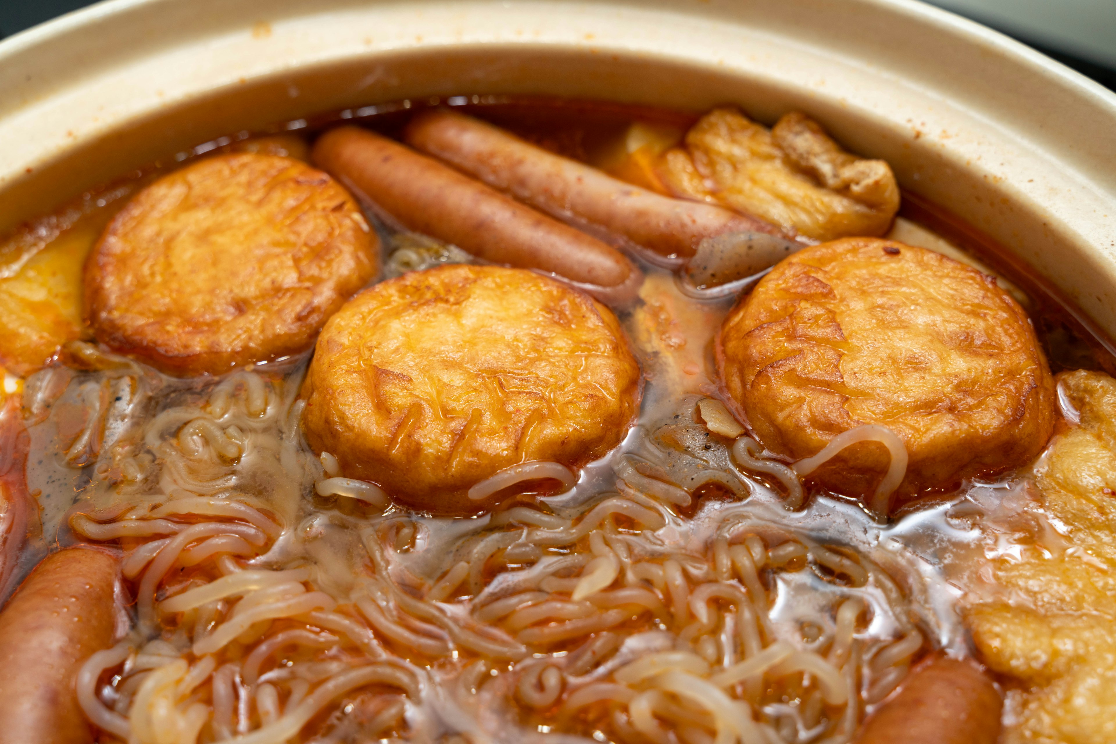 Olla caliente con fideos y pasteles de pescado frito