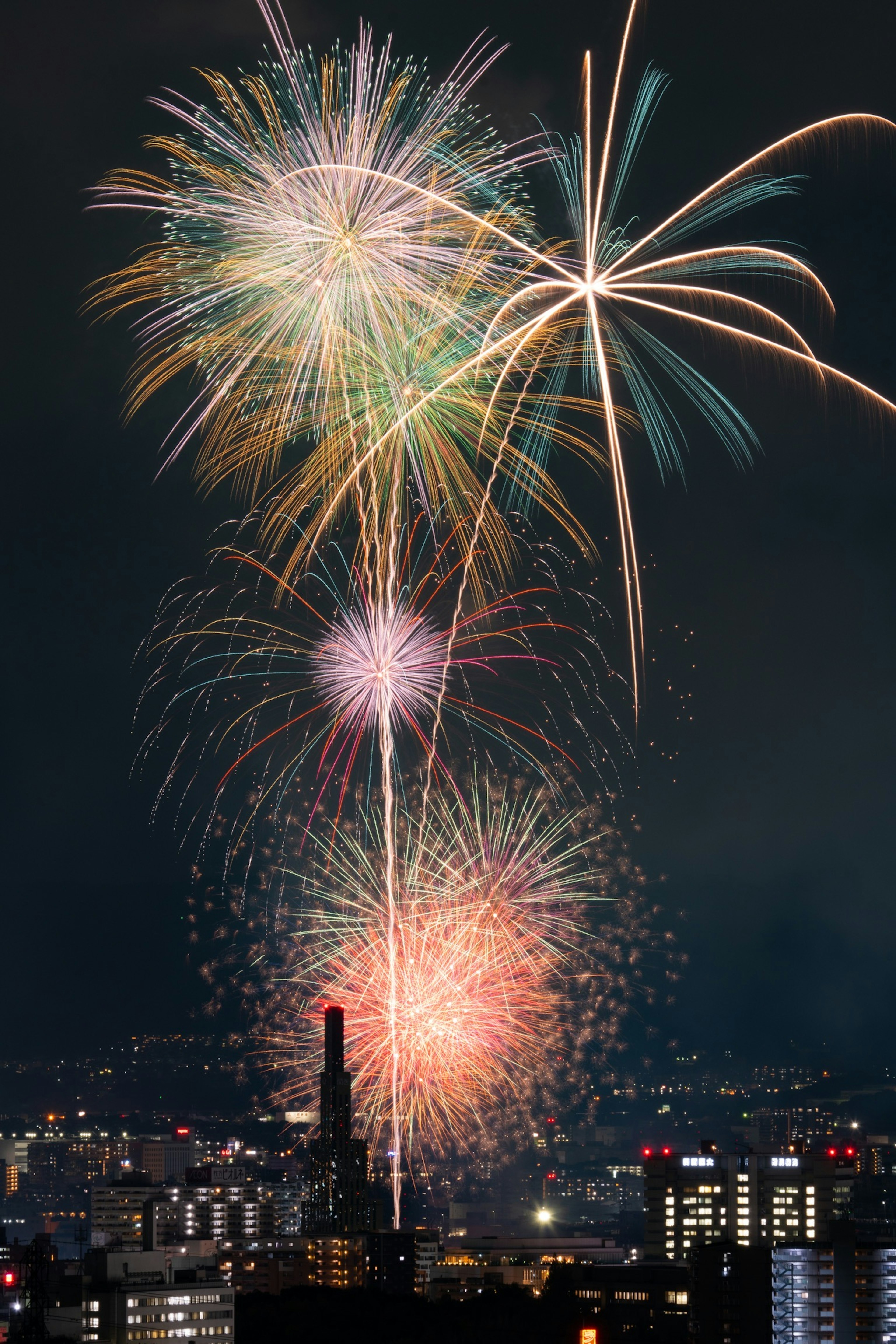 Colorful fireworks light up the night sky over a city skyline