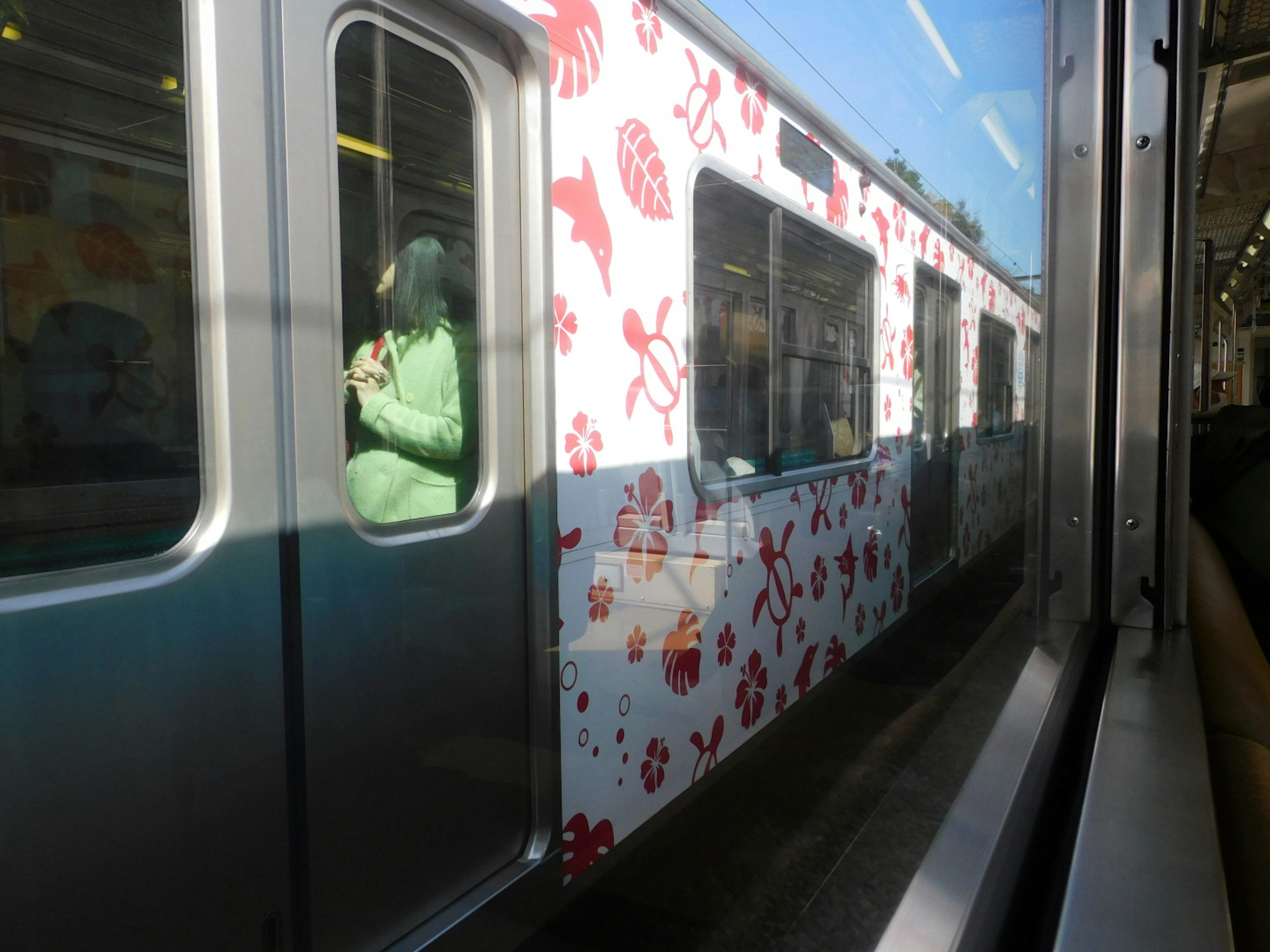 電車の側面に装飾された花のデザインを持つ列車が見える