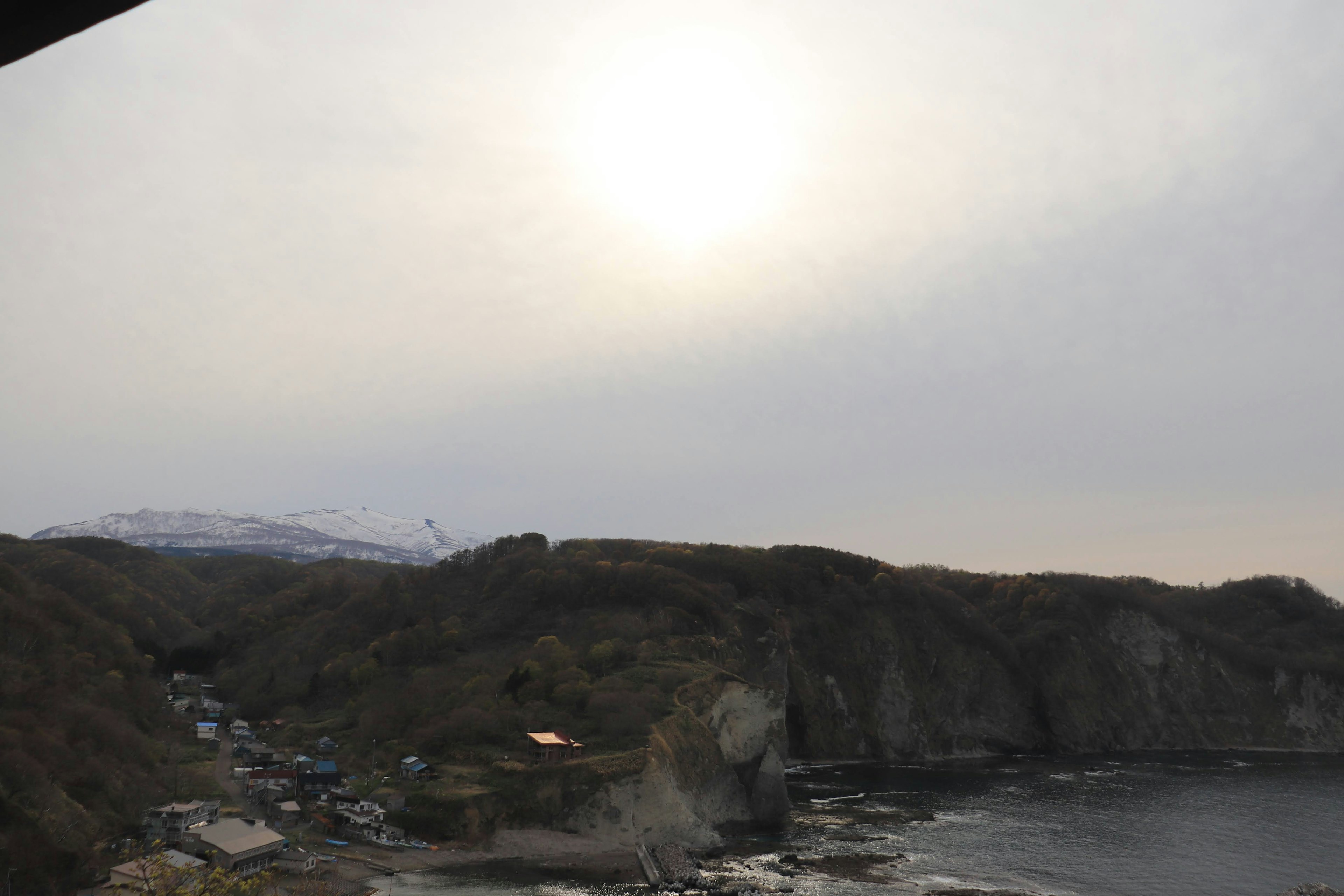 云层下的太阳照耀着海岸景观和丘陵