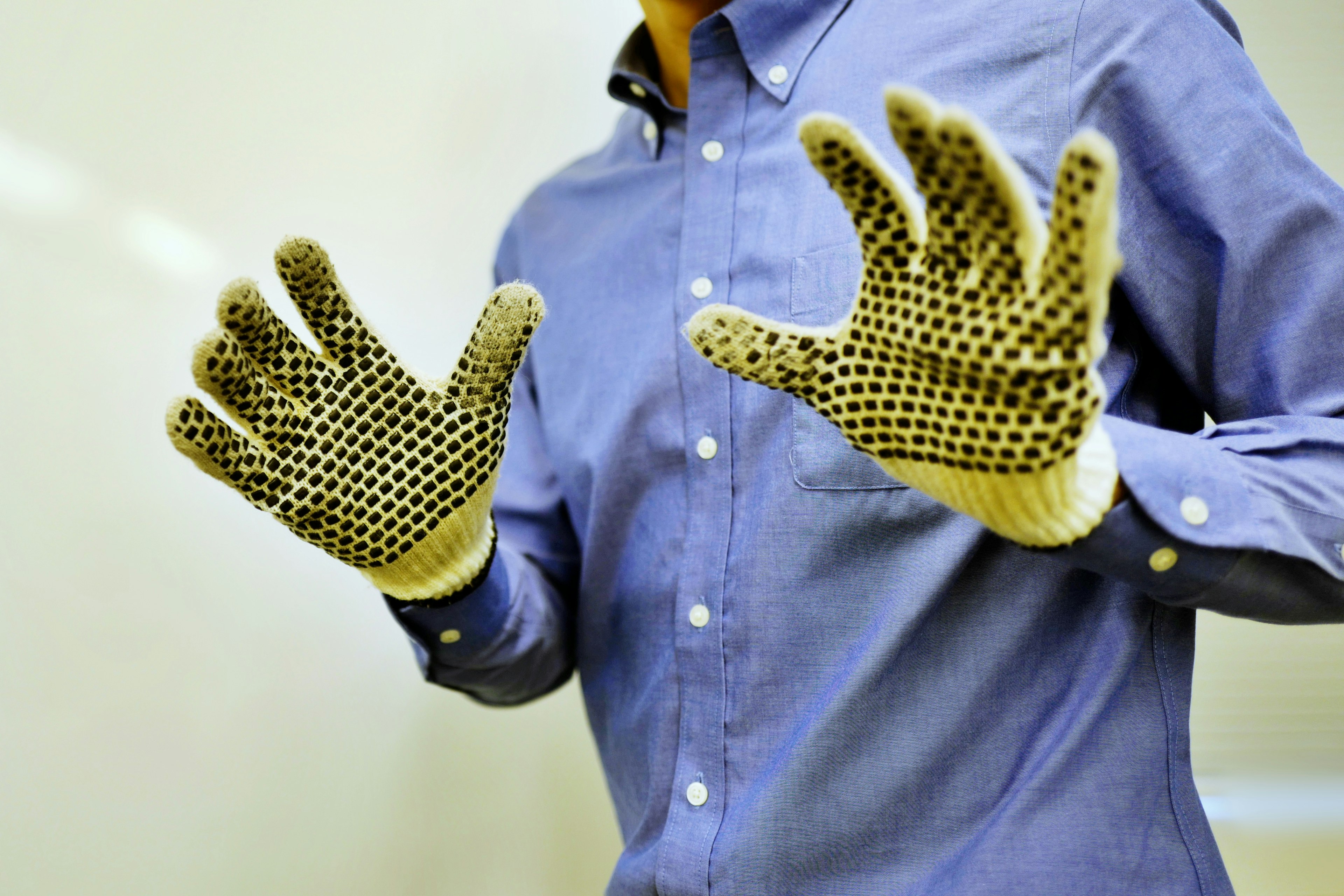 Person wearing textured gloves with hands raised