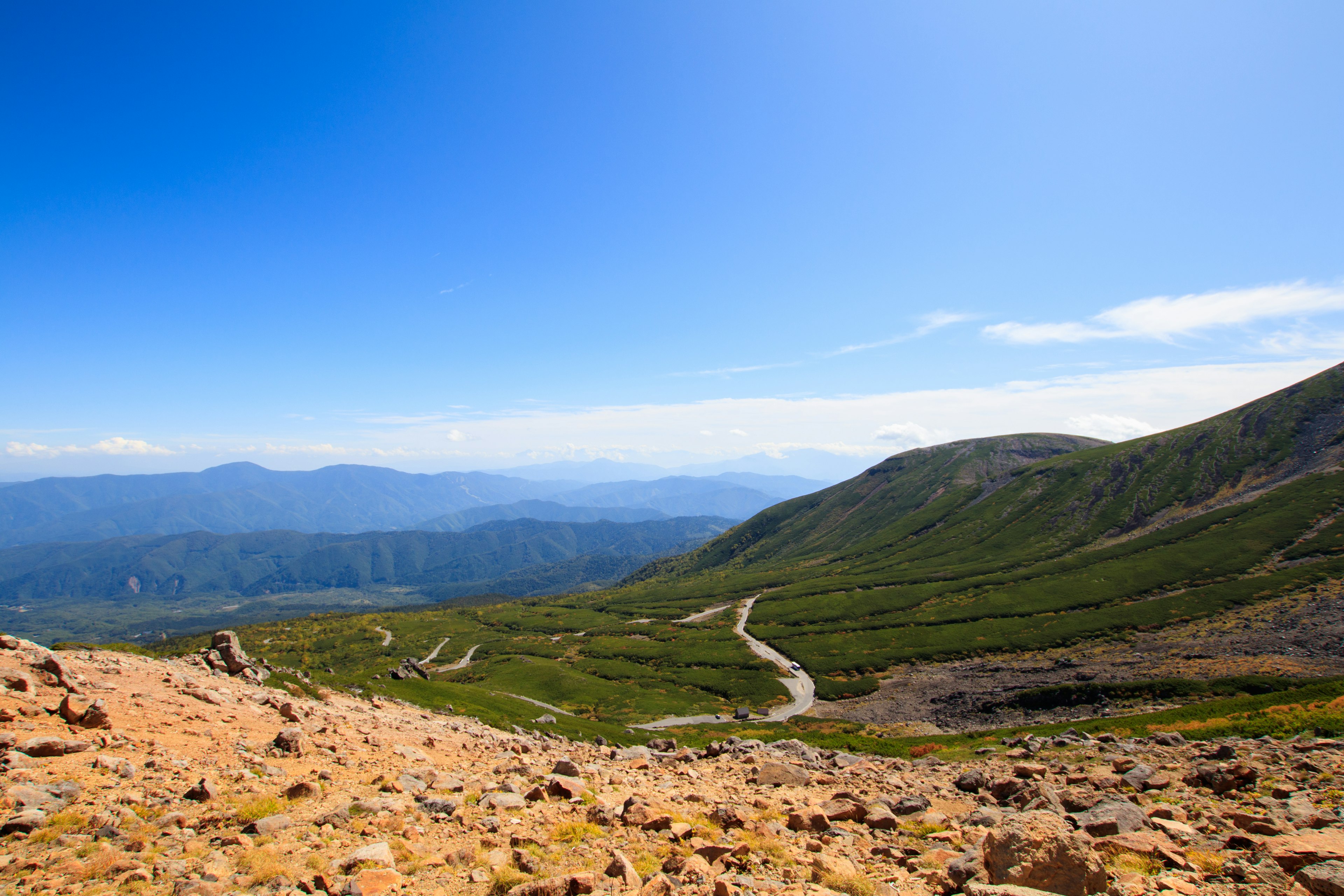 Berglandschaft mit grünen Hügeln und blauem Himmel