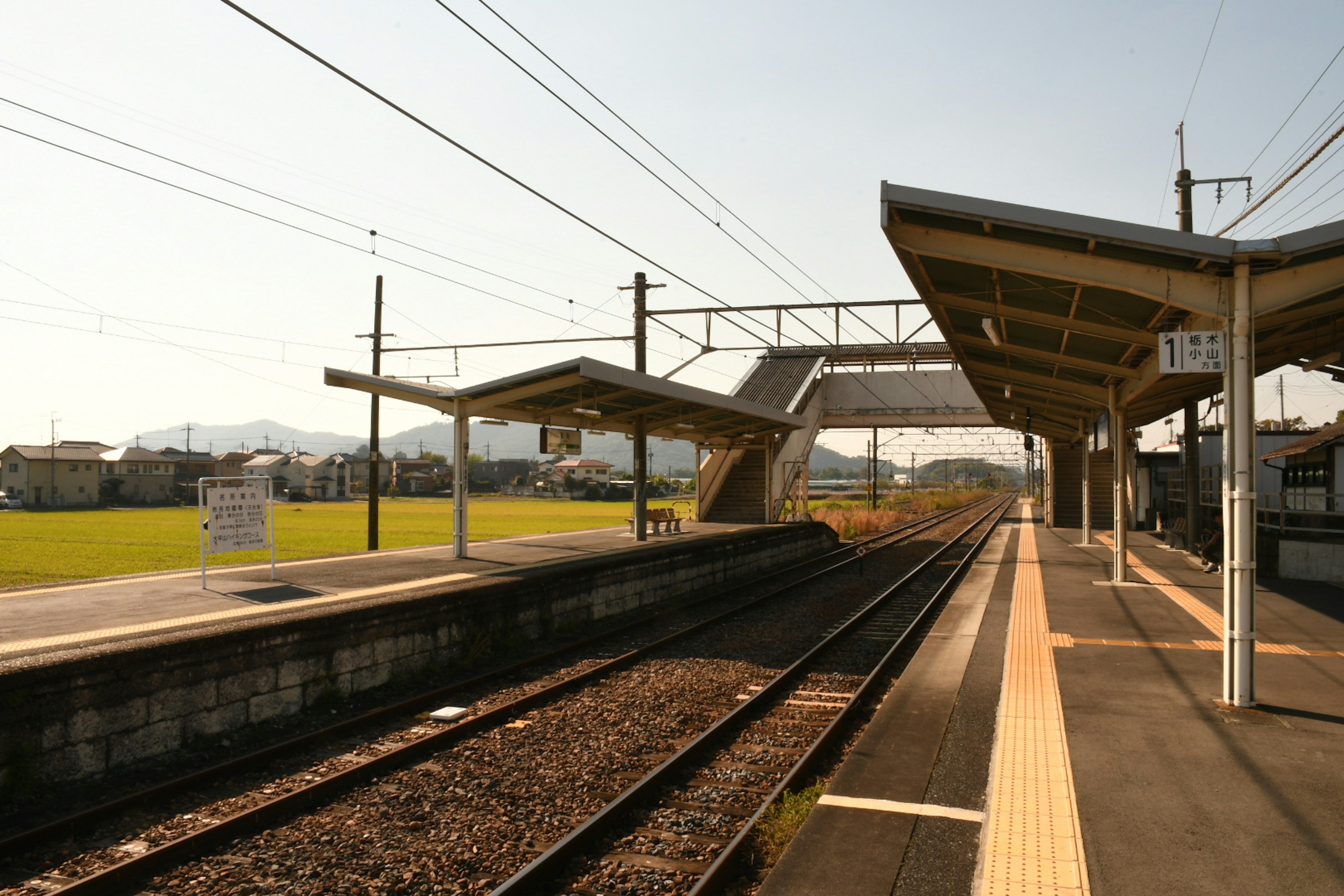 สถานีรถไฟชนบทพร้อมชานชาลาและรางรถไฟ