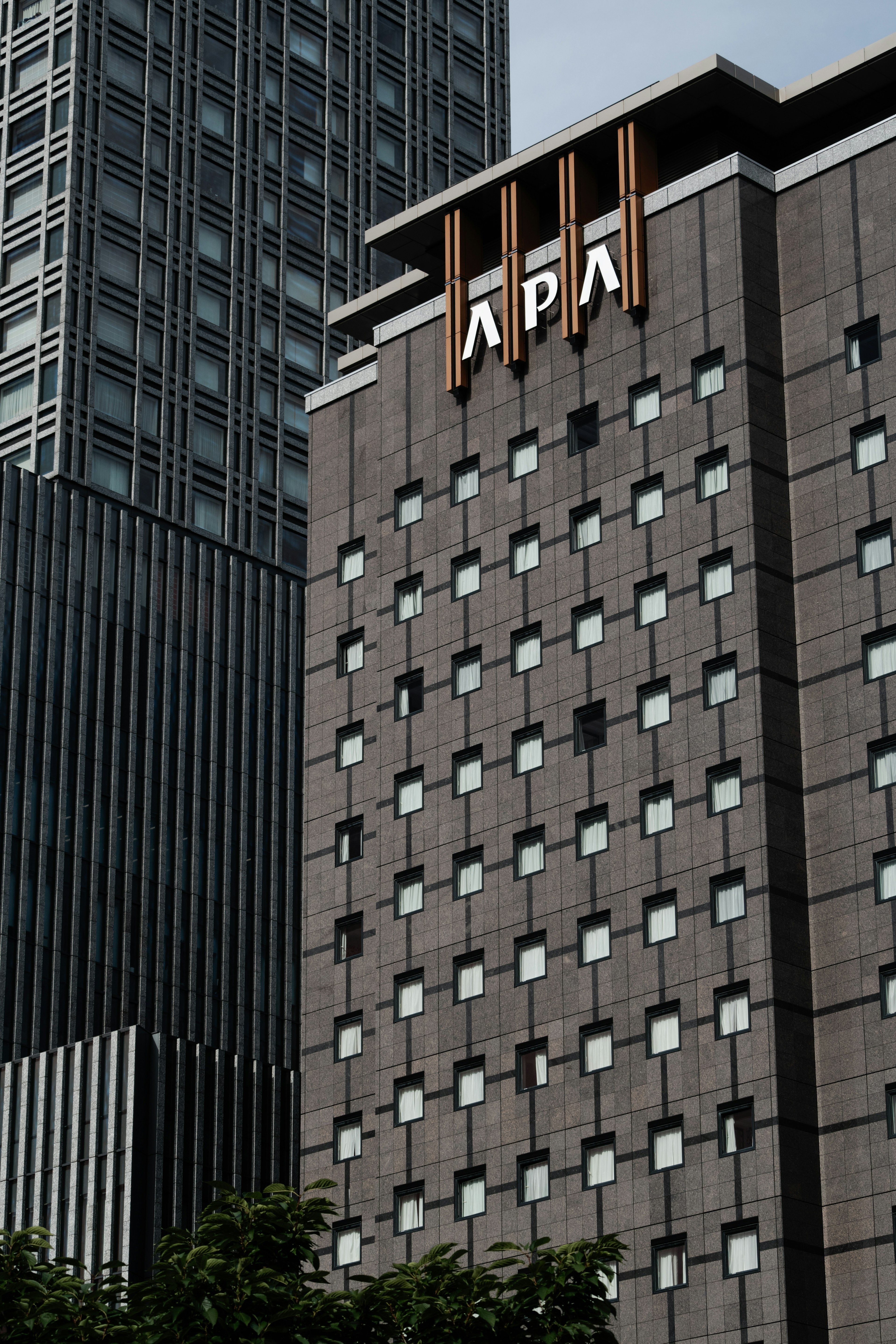 Exterior view of APA Hotel with surrounding skyscrapers