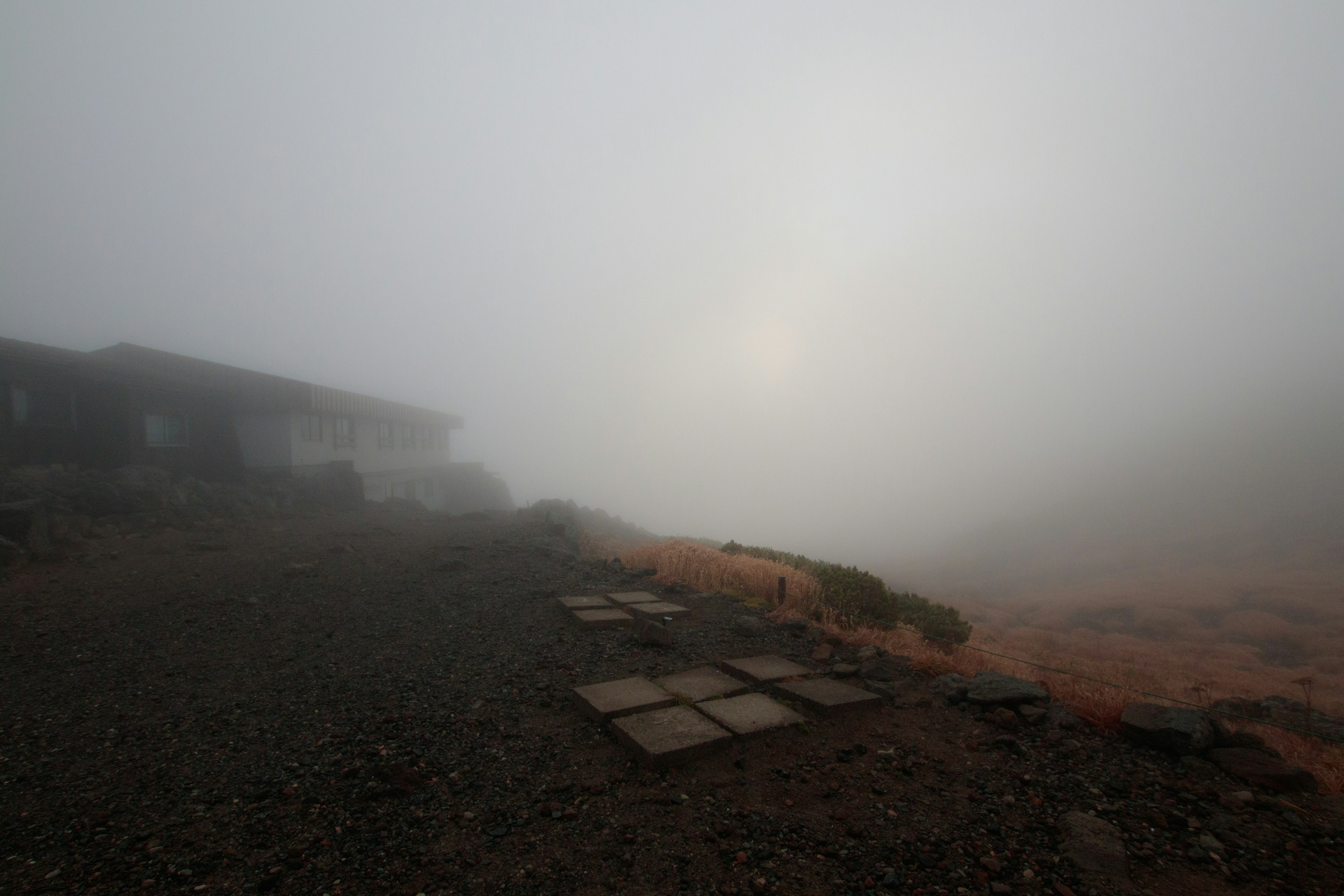 Paesaggio nebbioso con un edificio e pavimentazione in pietra