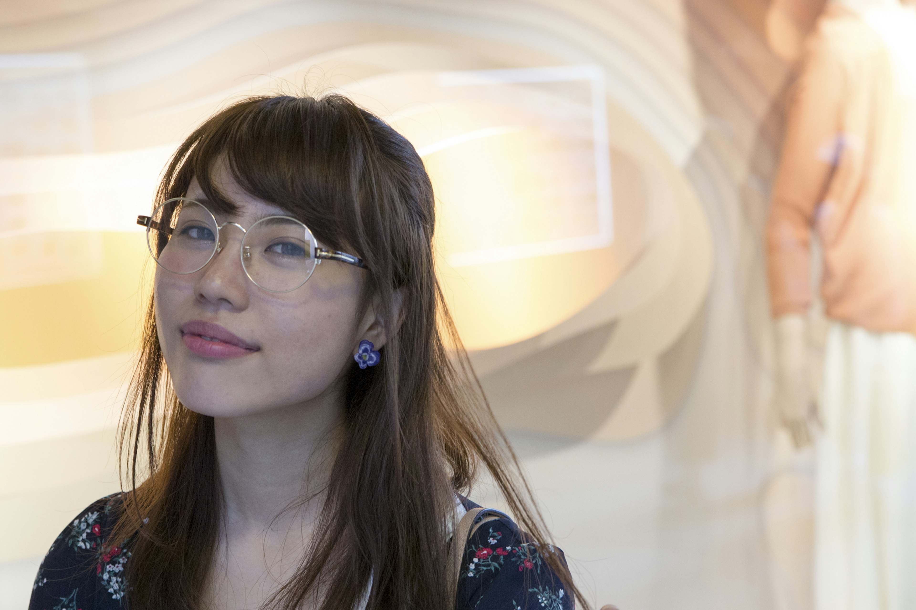 Une femme portant des lunettes souriante avec un fond de design abstrait