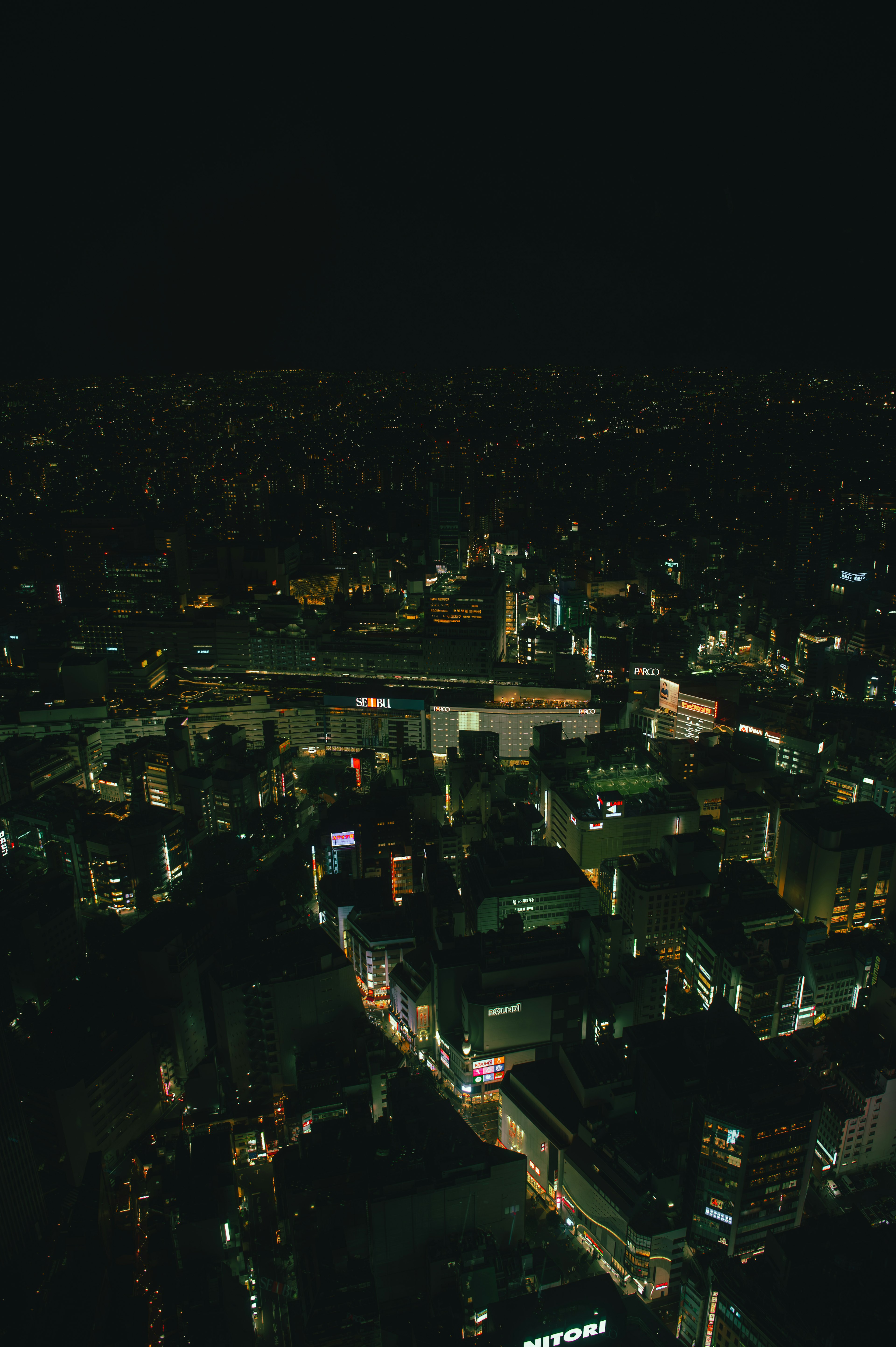 Aerial view of a cityscape at night with illuminated buildings and streets