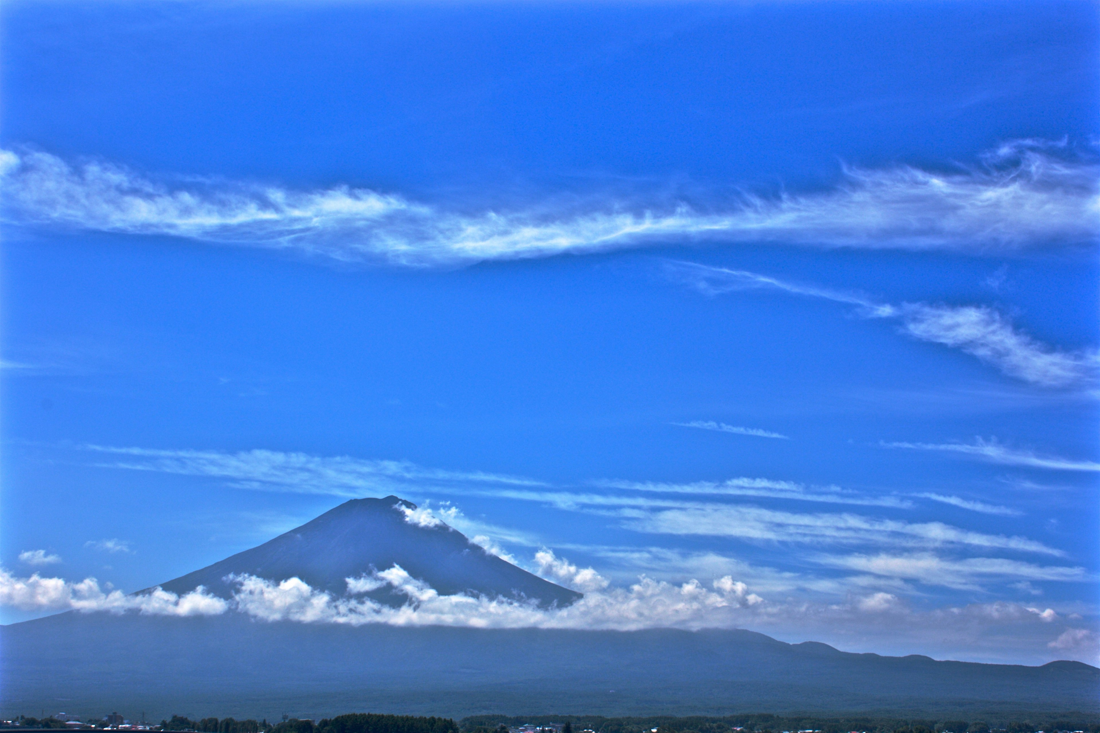 青い空を背景に富士山がそびえ立つ雲の風景