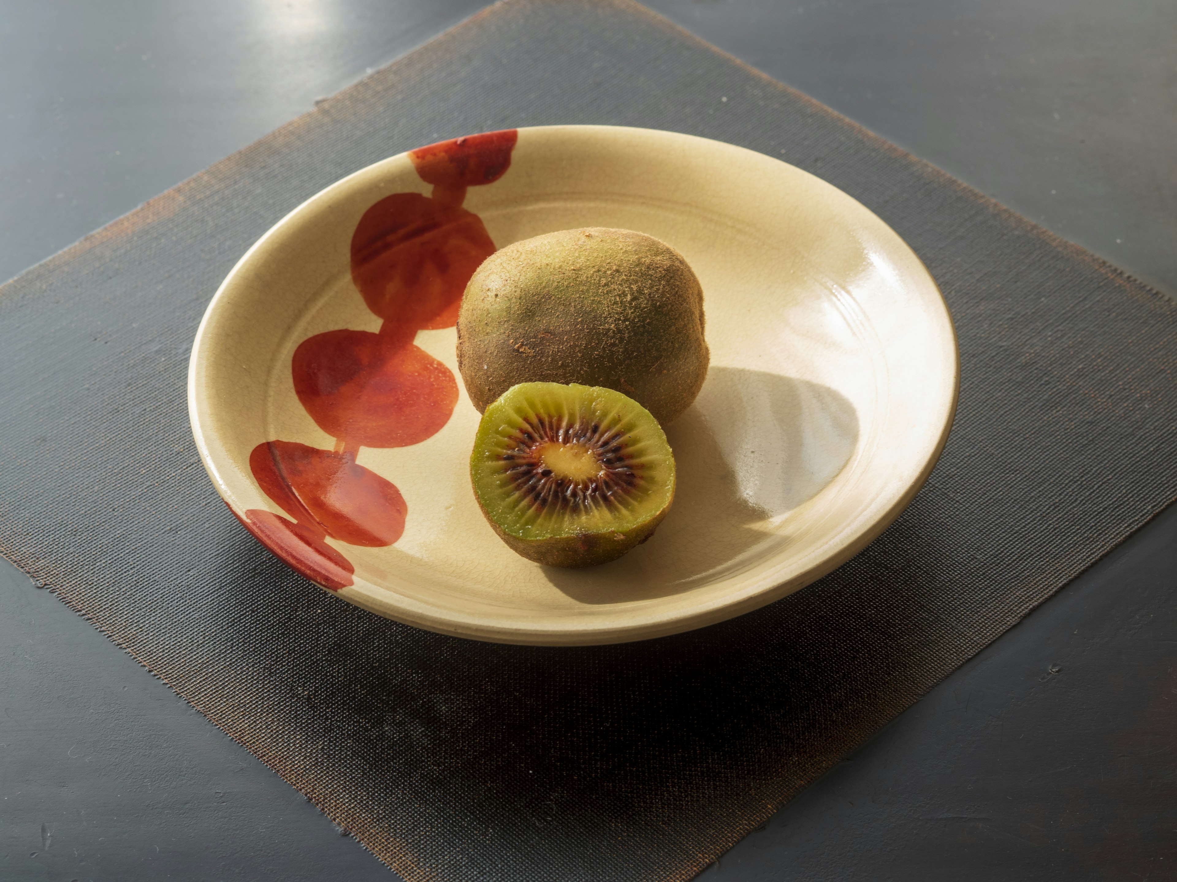 Un piatto in ceramica con kiwi e patate