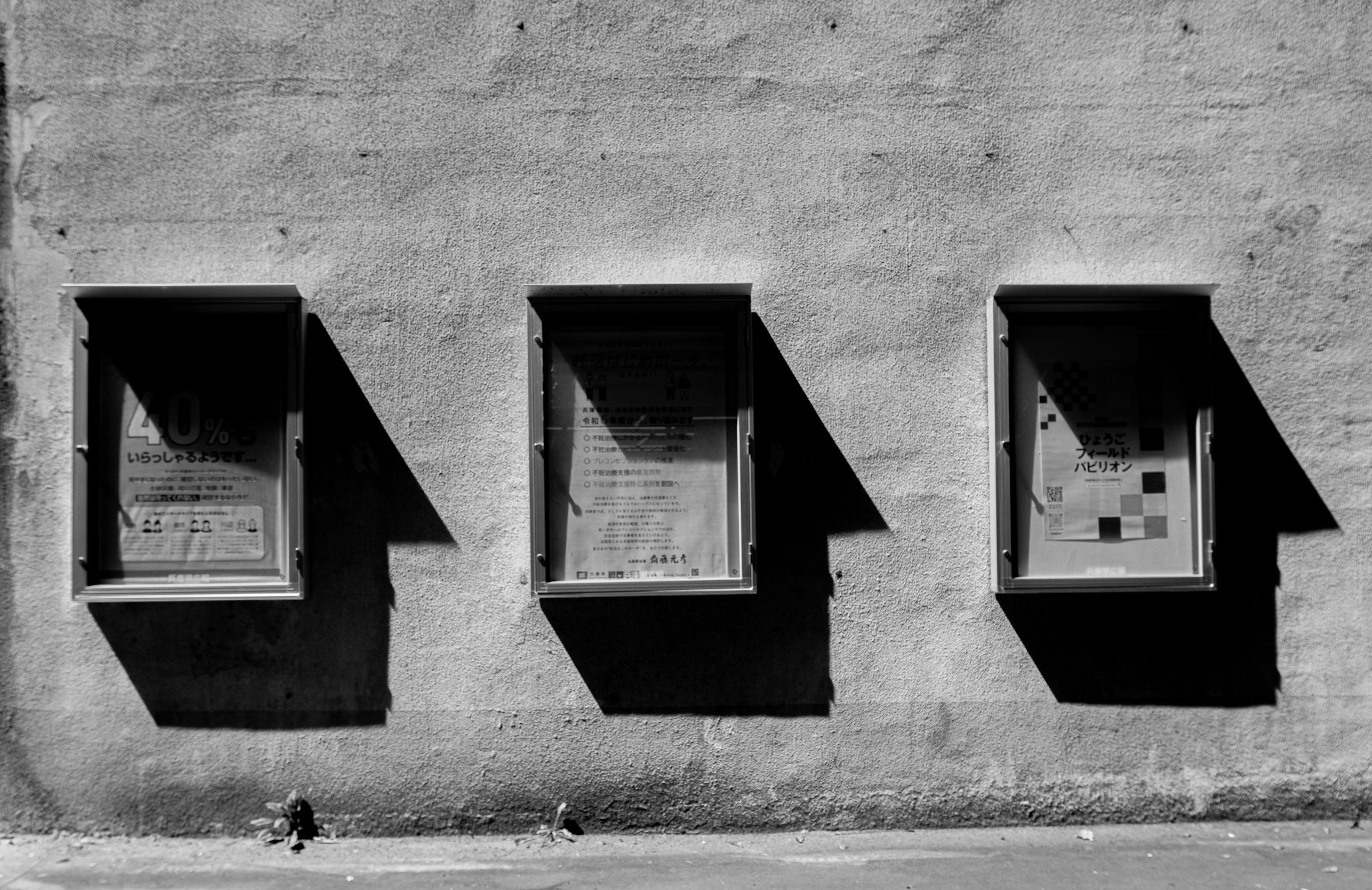 Drei Fenster, die Schatten auf eine strukturierte Wand werfen