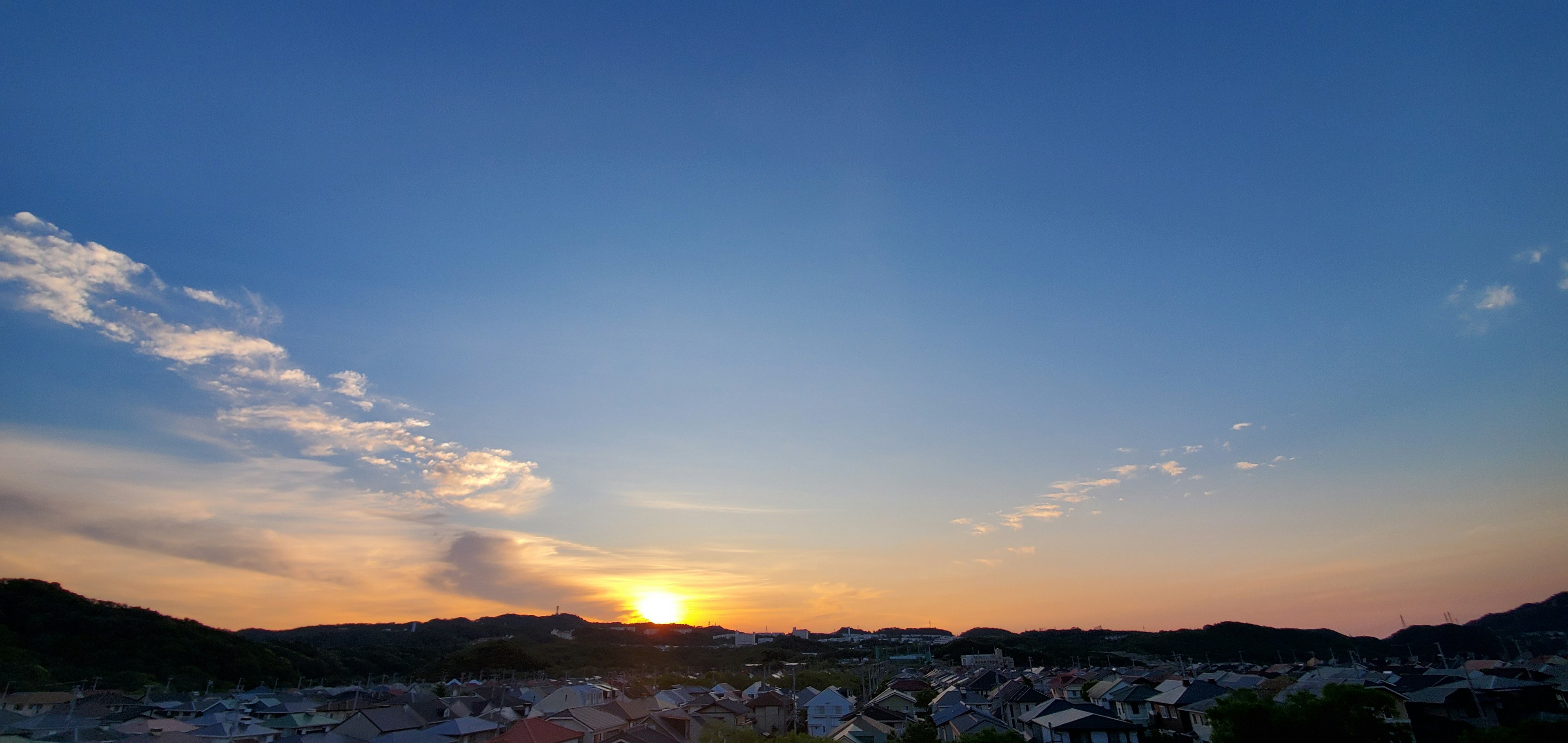 Bellissimo paesaggio al tramonto con cielo blu e sole arancione che tramonta