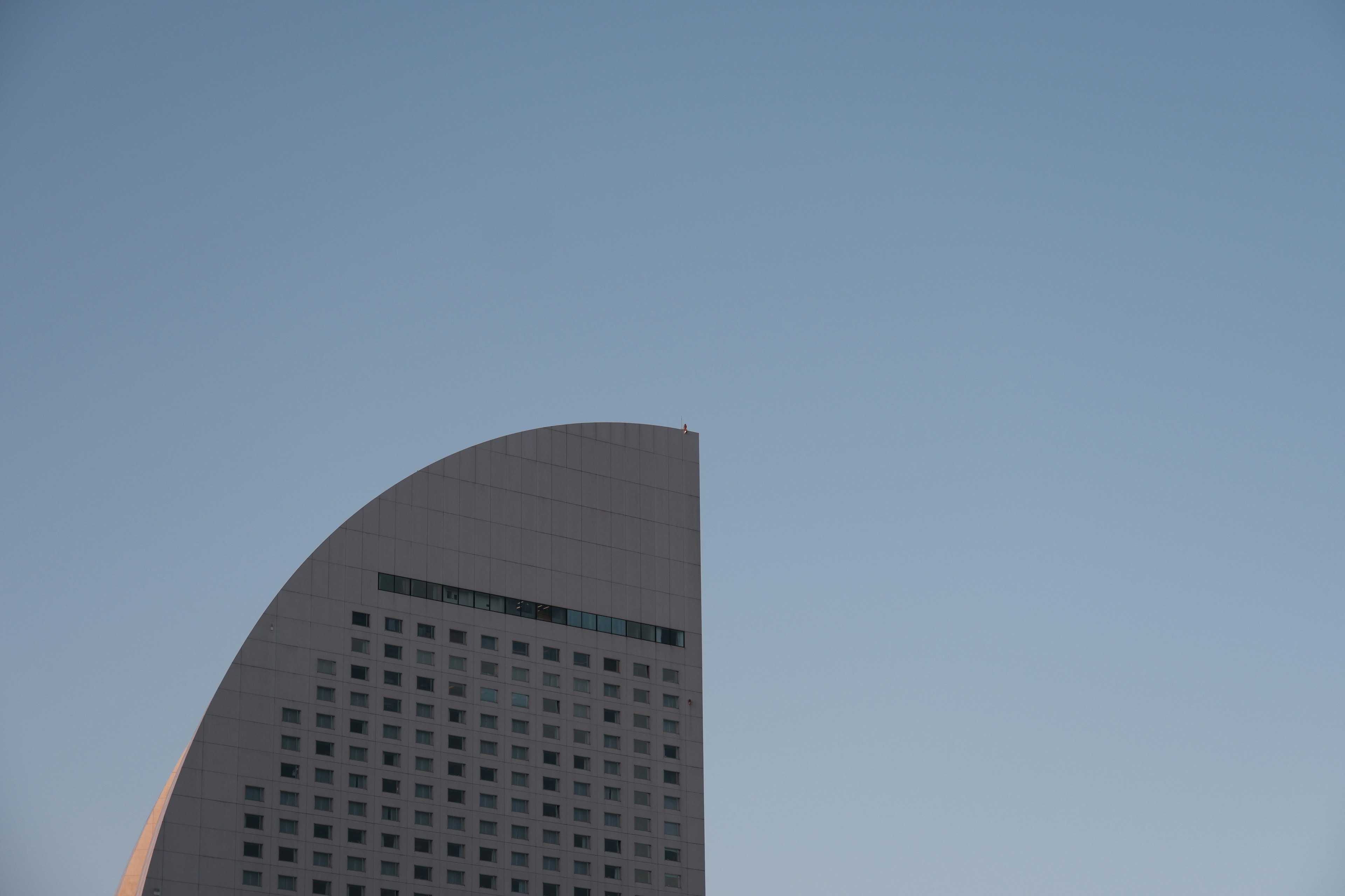 Part of a modern building against a blue sky