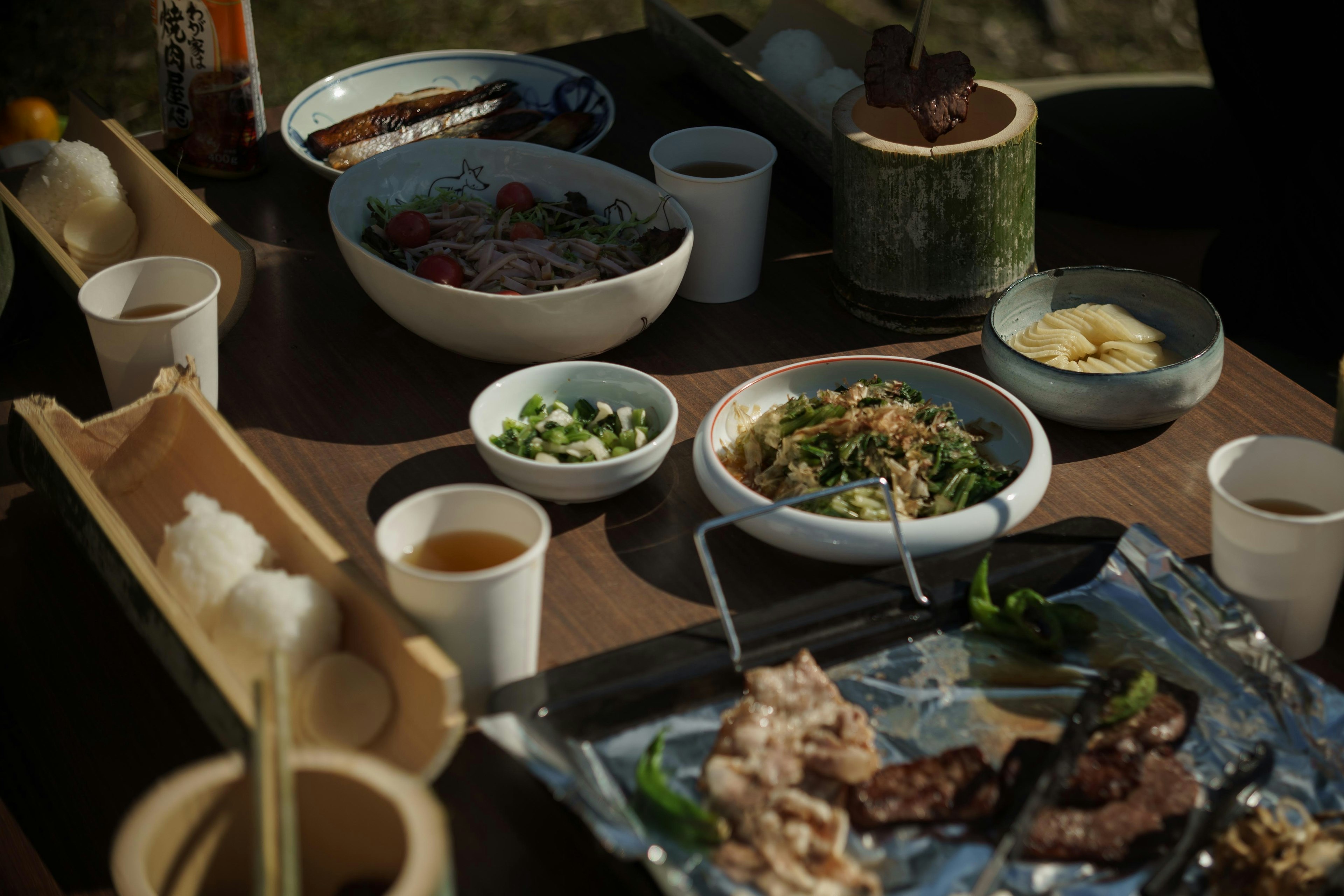 Escena de comida al aire libre con una variedad de platos en la mesa