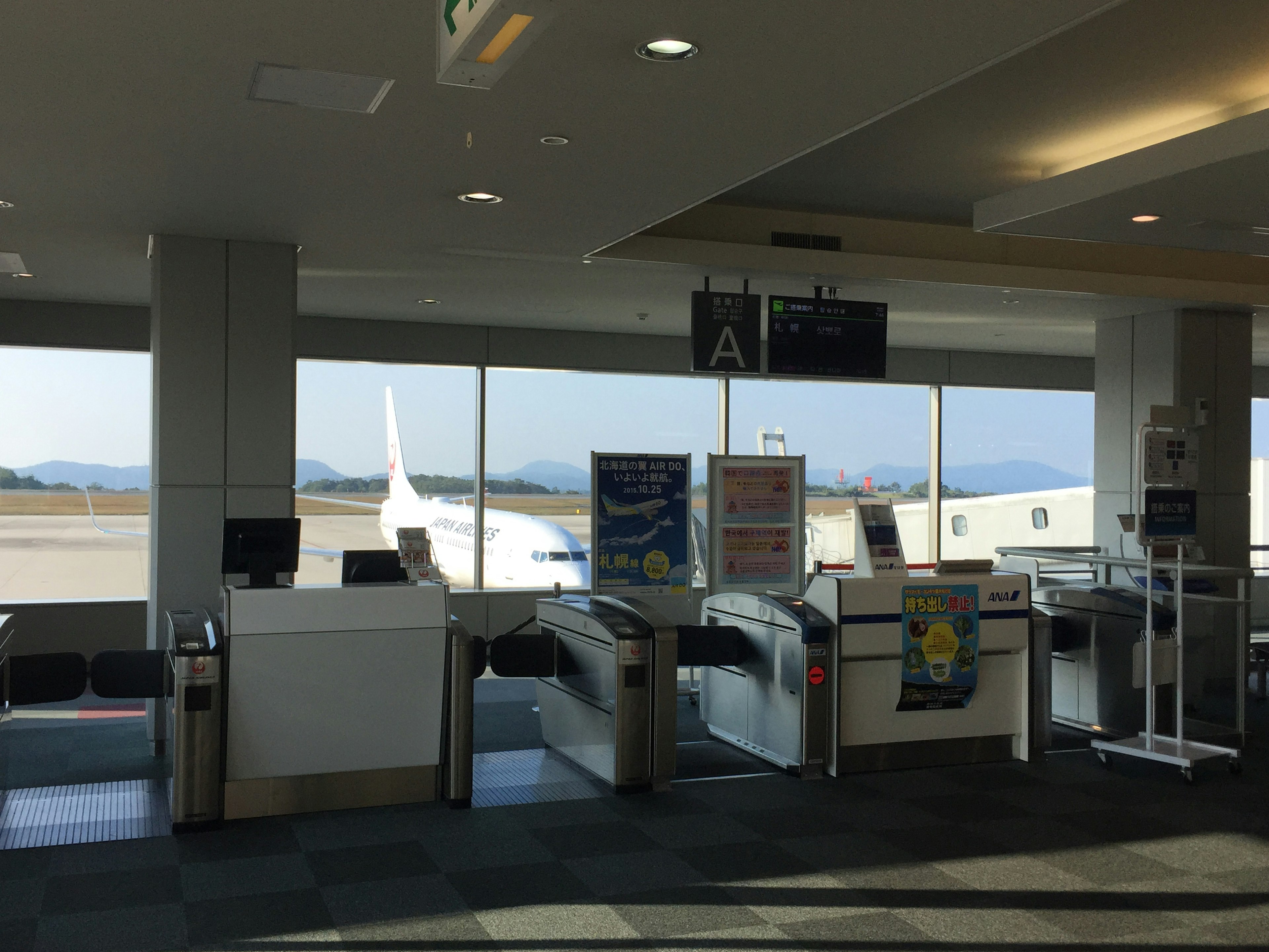 Innensicht eines Flughafen-Gates mit einem sichtbaren Flugzeug außerhalb des Fensters