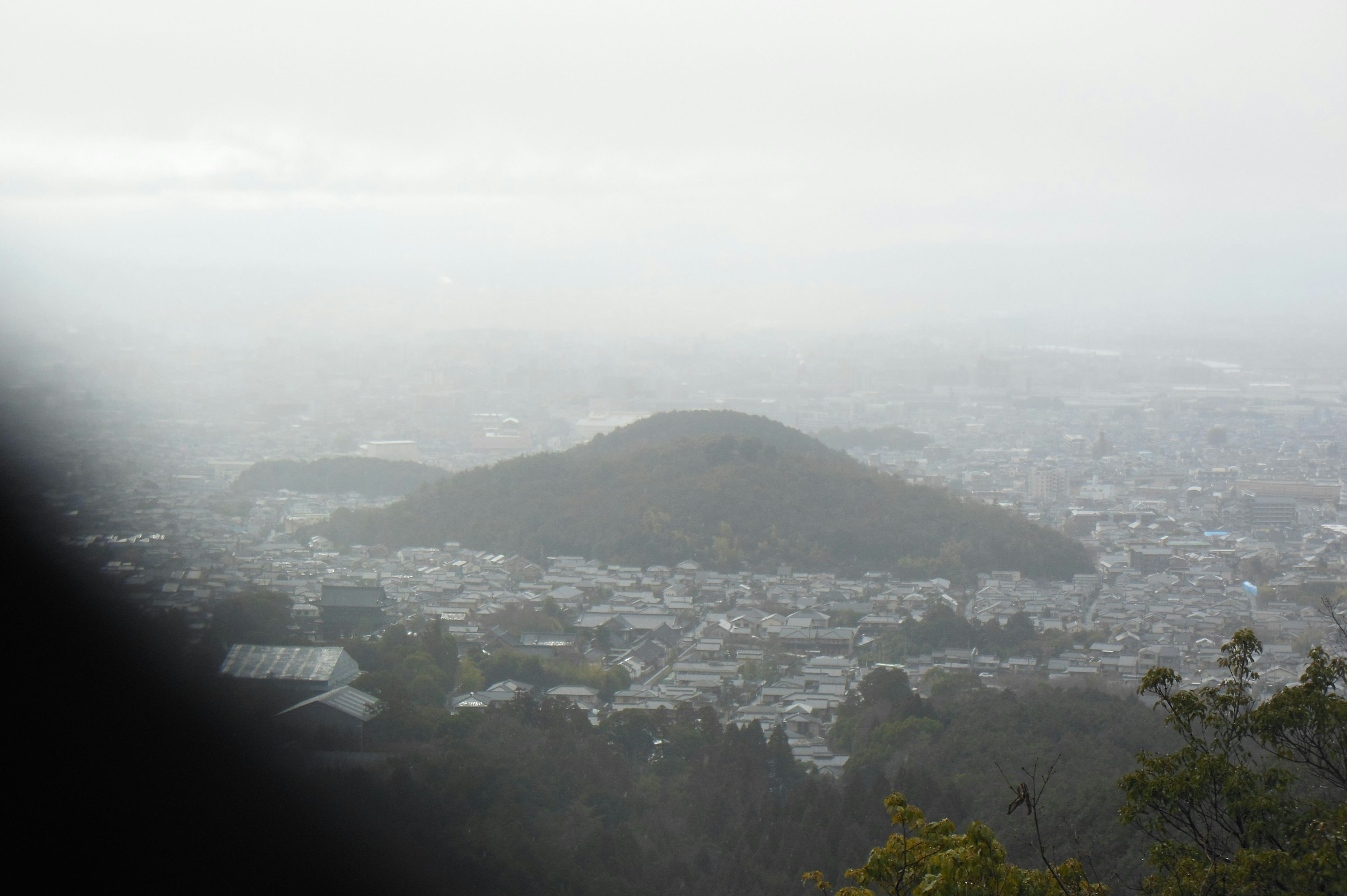 Vista nublada de una montaña y una ciudad