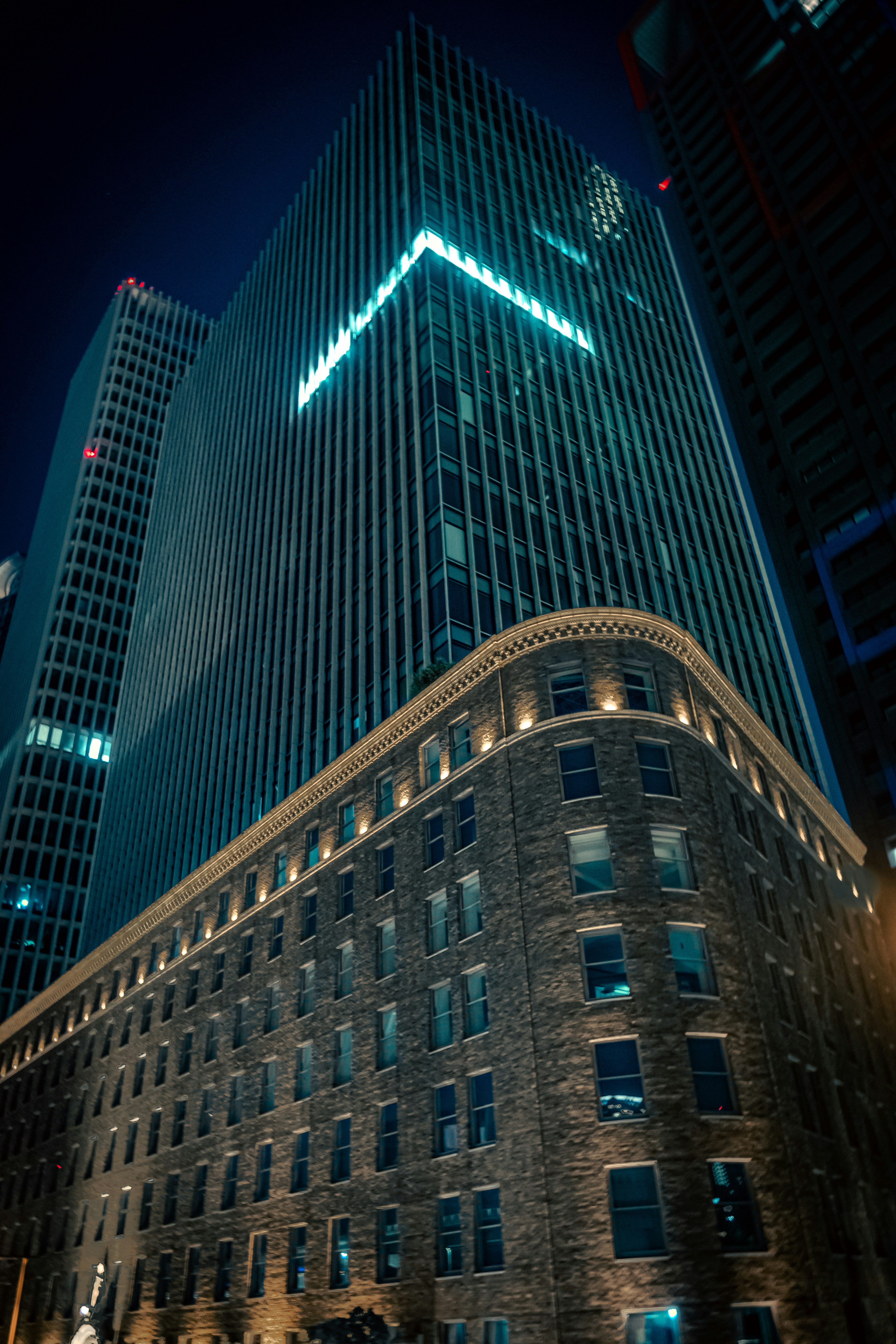 Scène nocturne de la ville avec un gratte-ciel moderne et un bâtiment historique