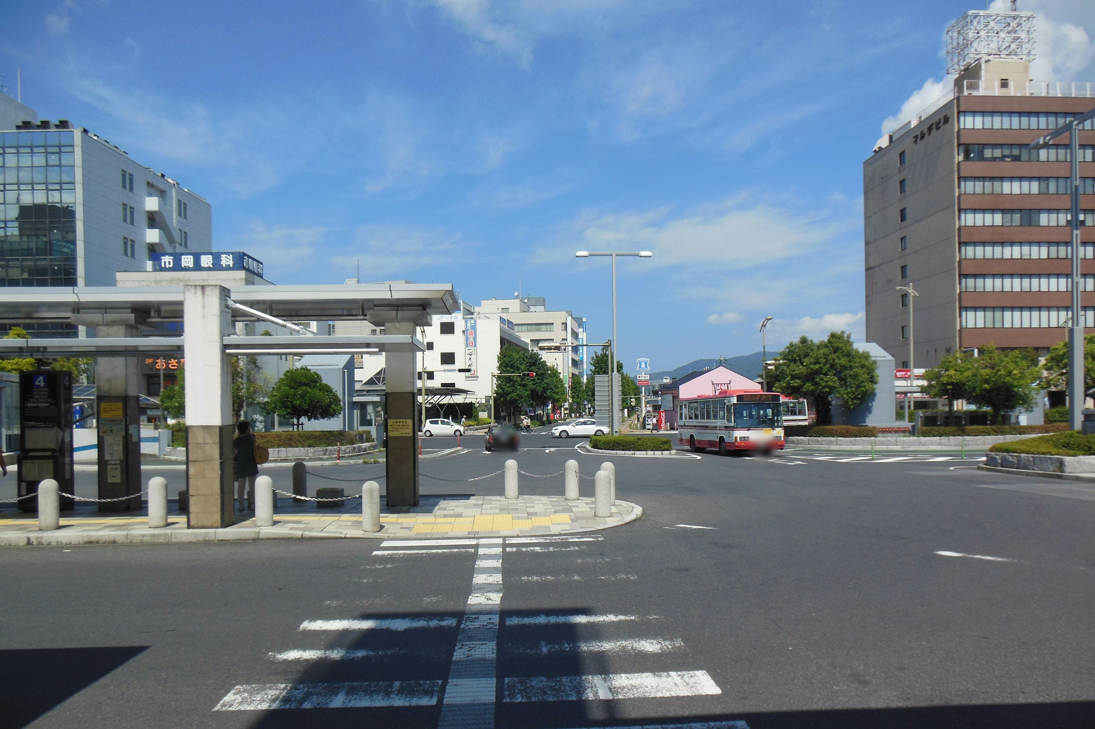 Intersection with a bus stop and buildings under blue sky