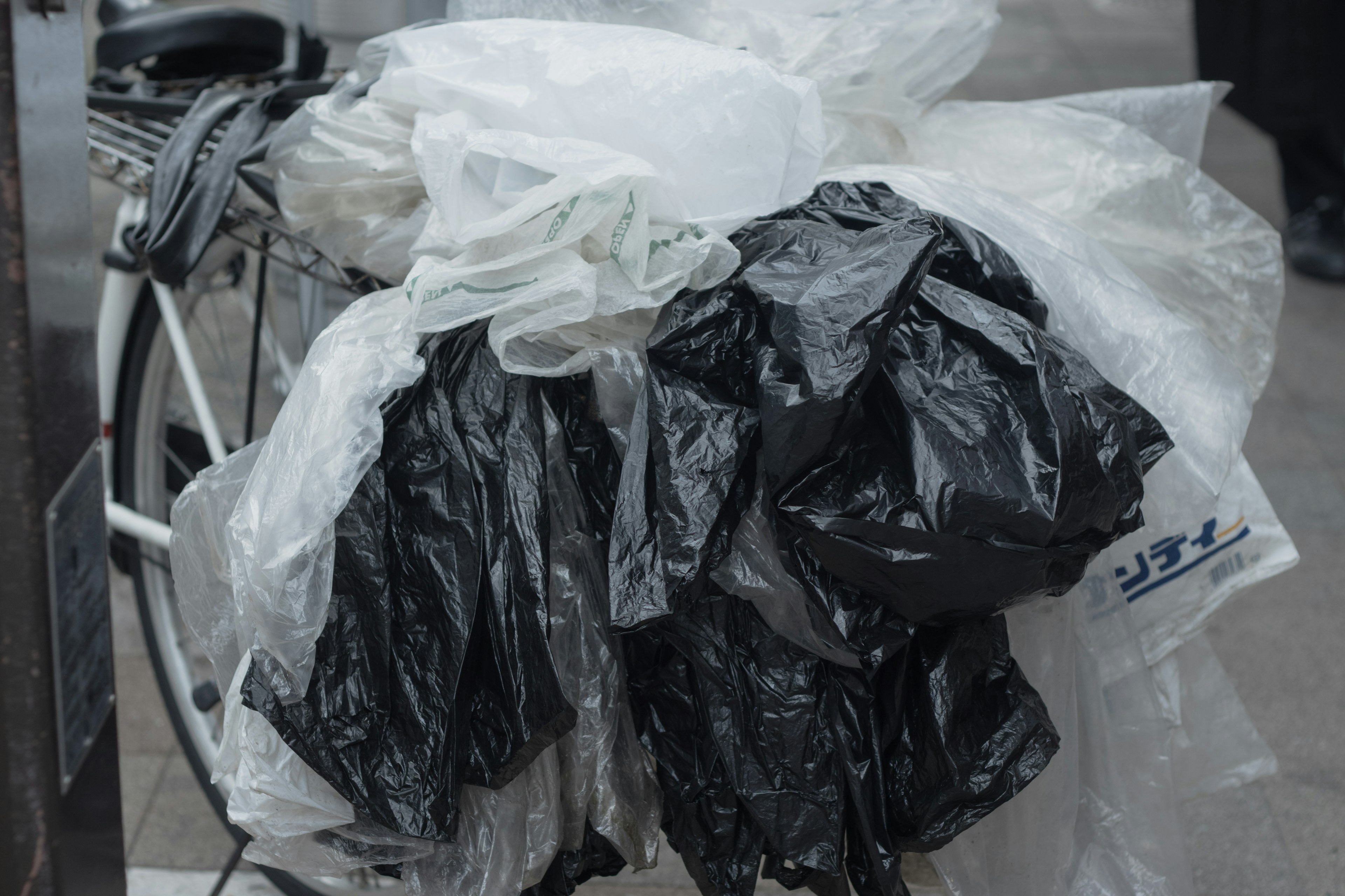 Un montón de bolsas de plástico blancas y negras sobre una bicicleta