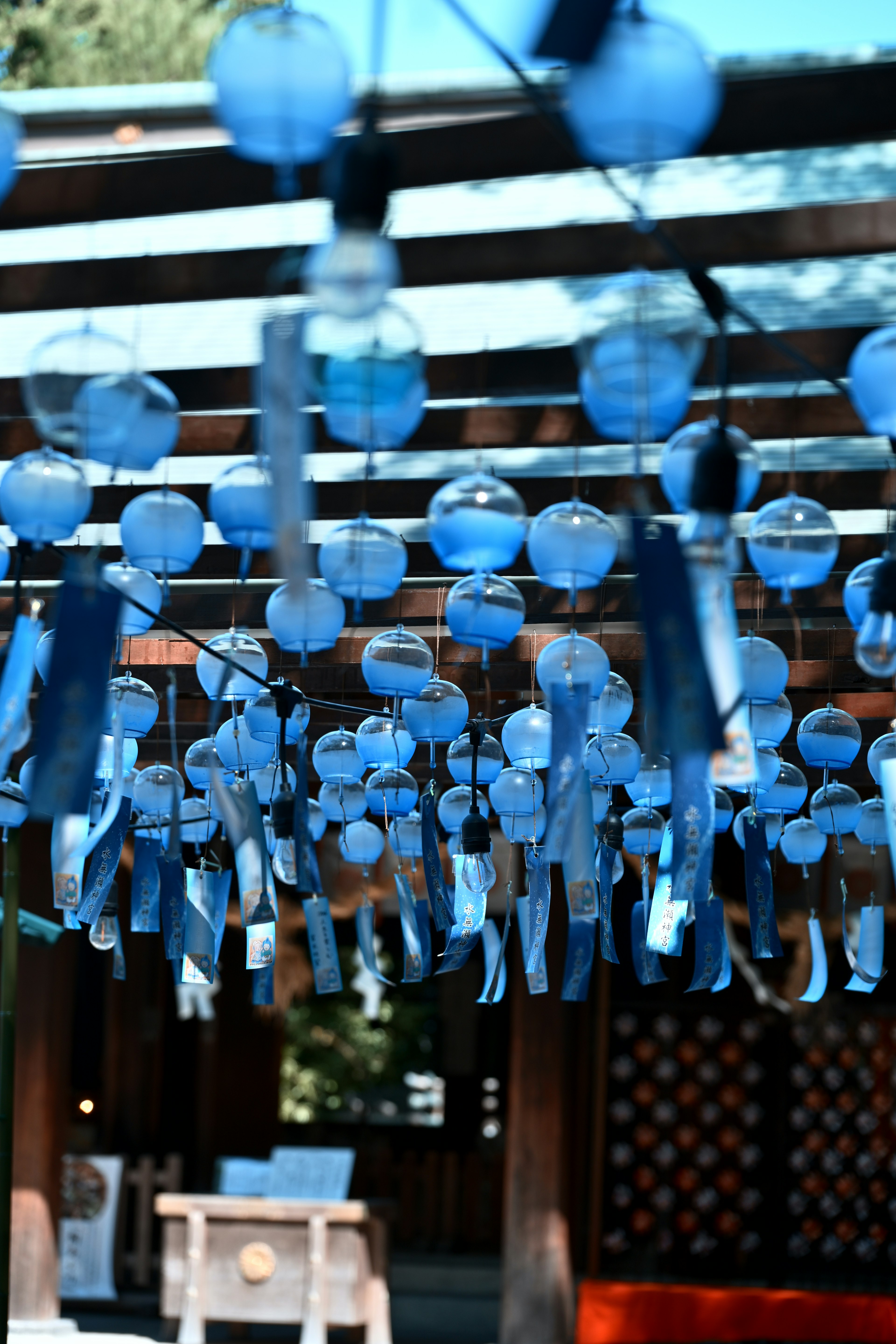 Traditional Japanese building adorned with hanging blue wind chimes