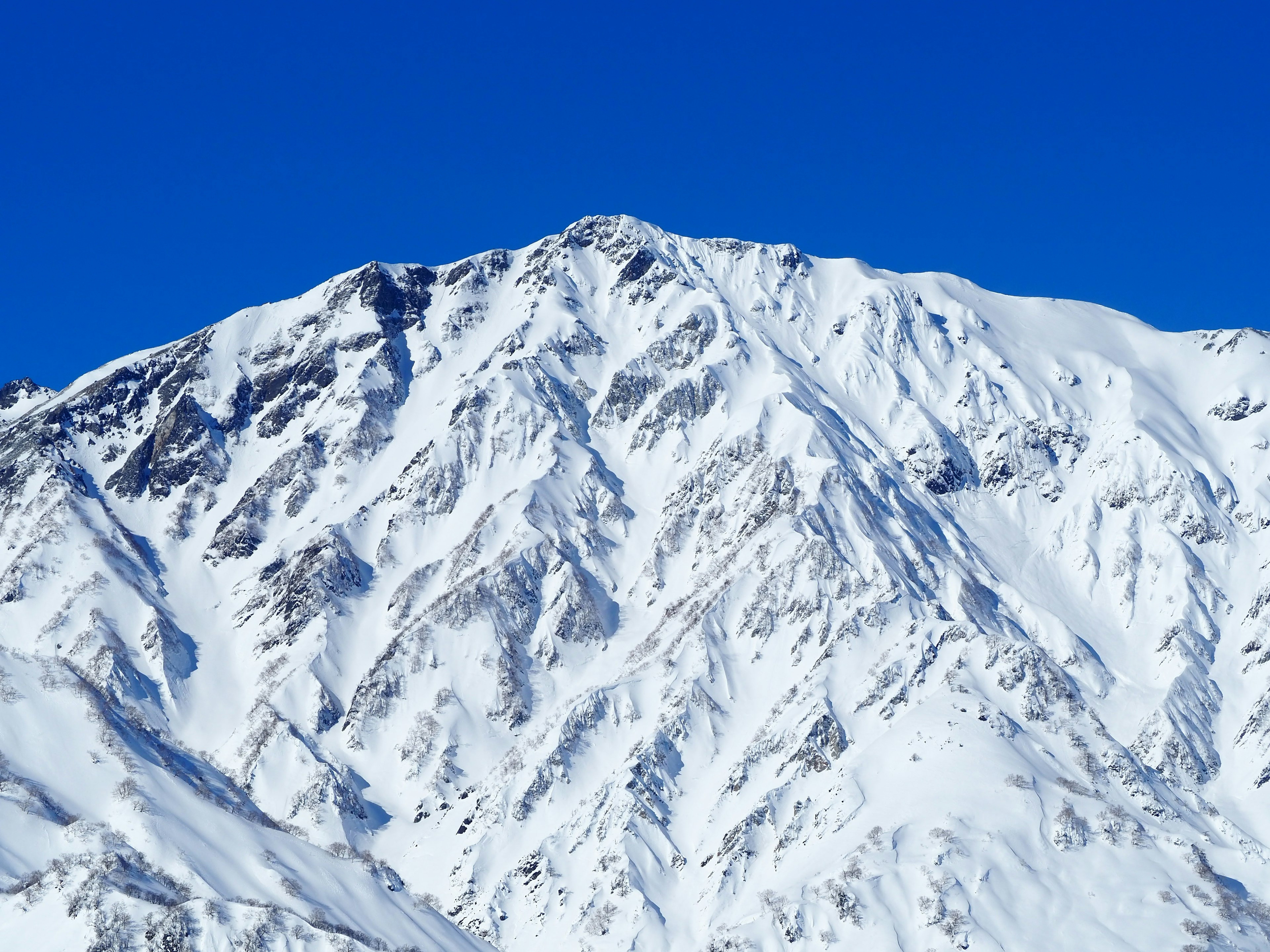 Paesaggio montano innevato contro un cielo blu