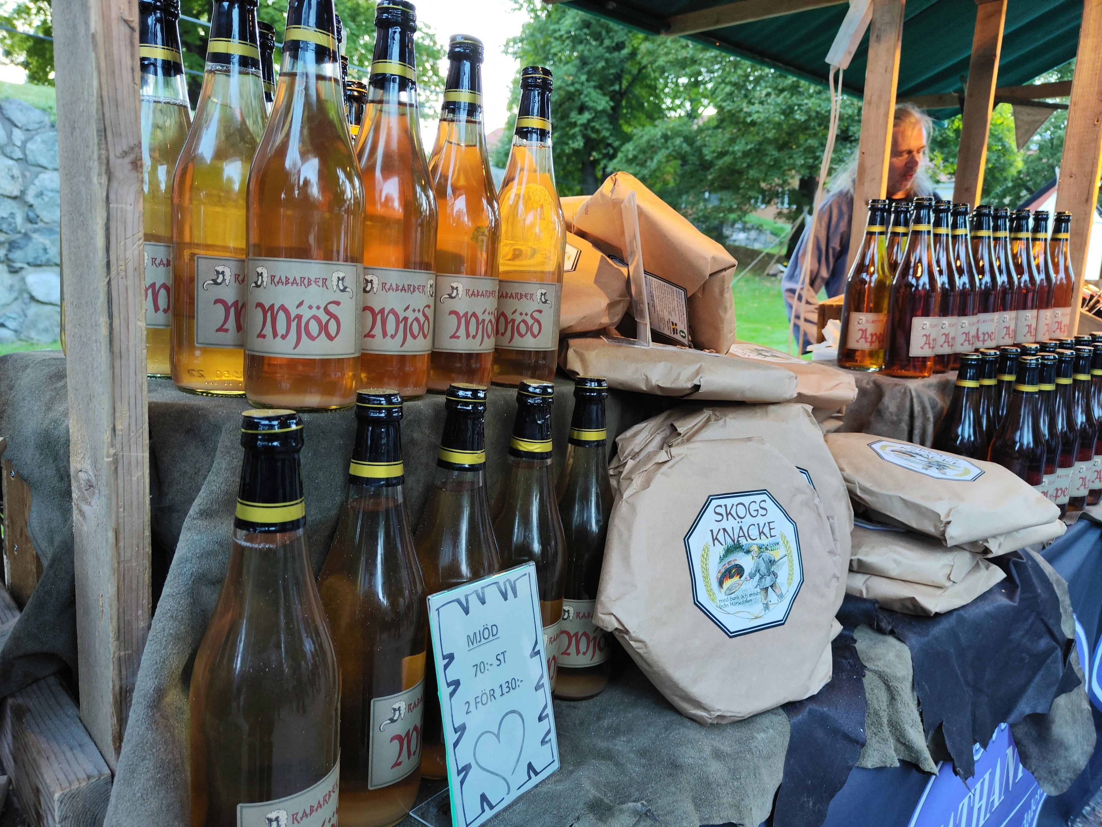 Botellas coloridas y productos empaquetados exhibidos en un puesto de mercado