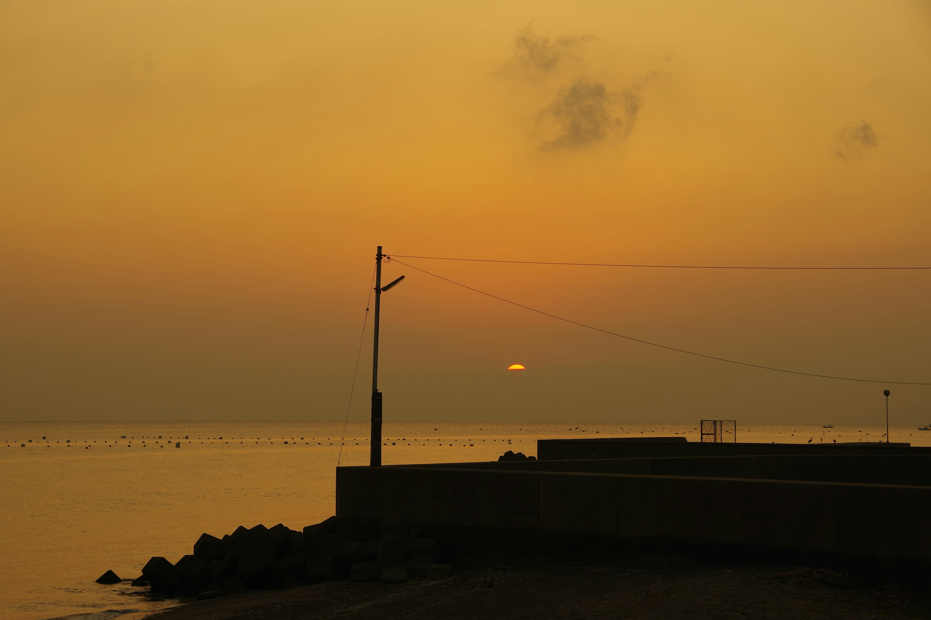 Ruhige Küstenszene bei Sonnenuntergang mit orangefarbenem Himmel