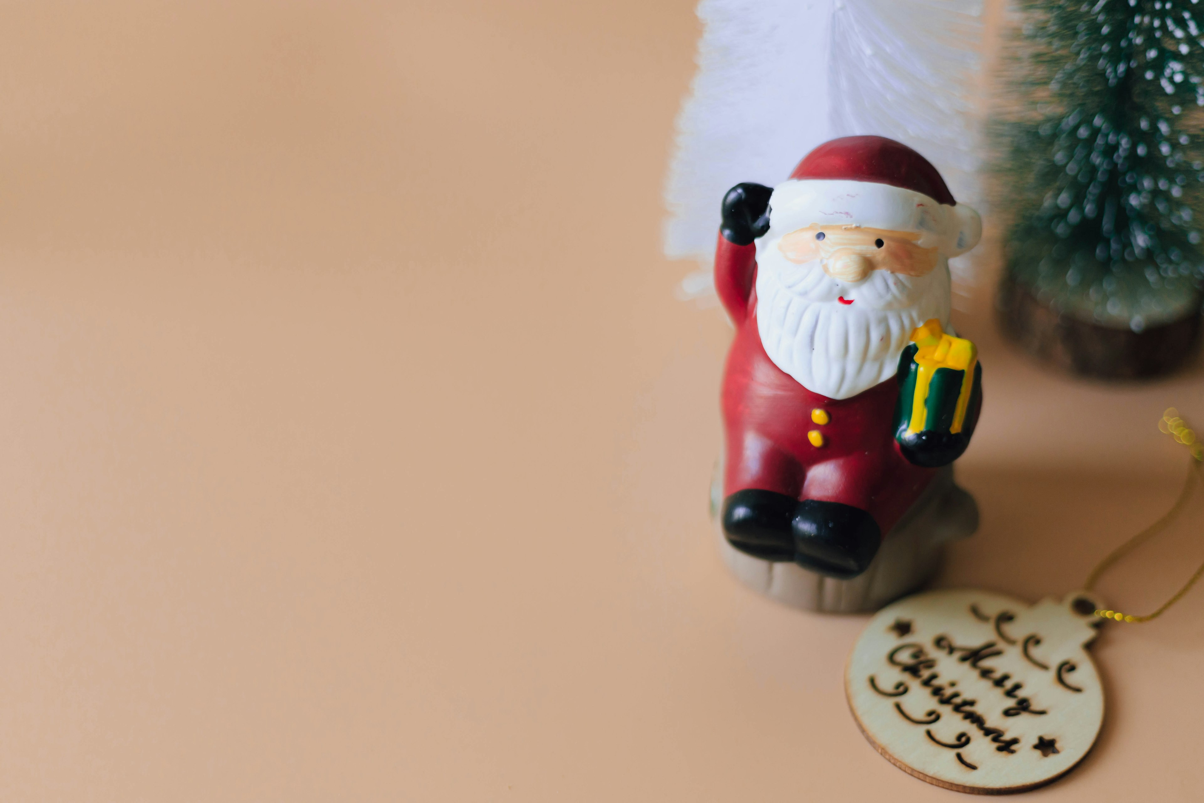 A Santa Claus figurine in red holding a gift