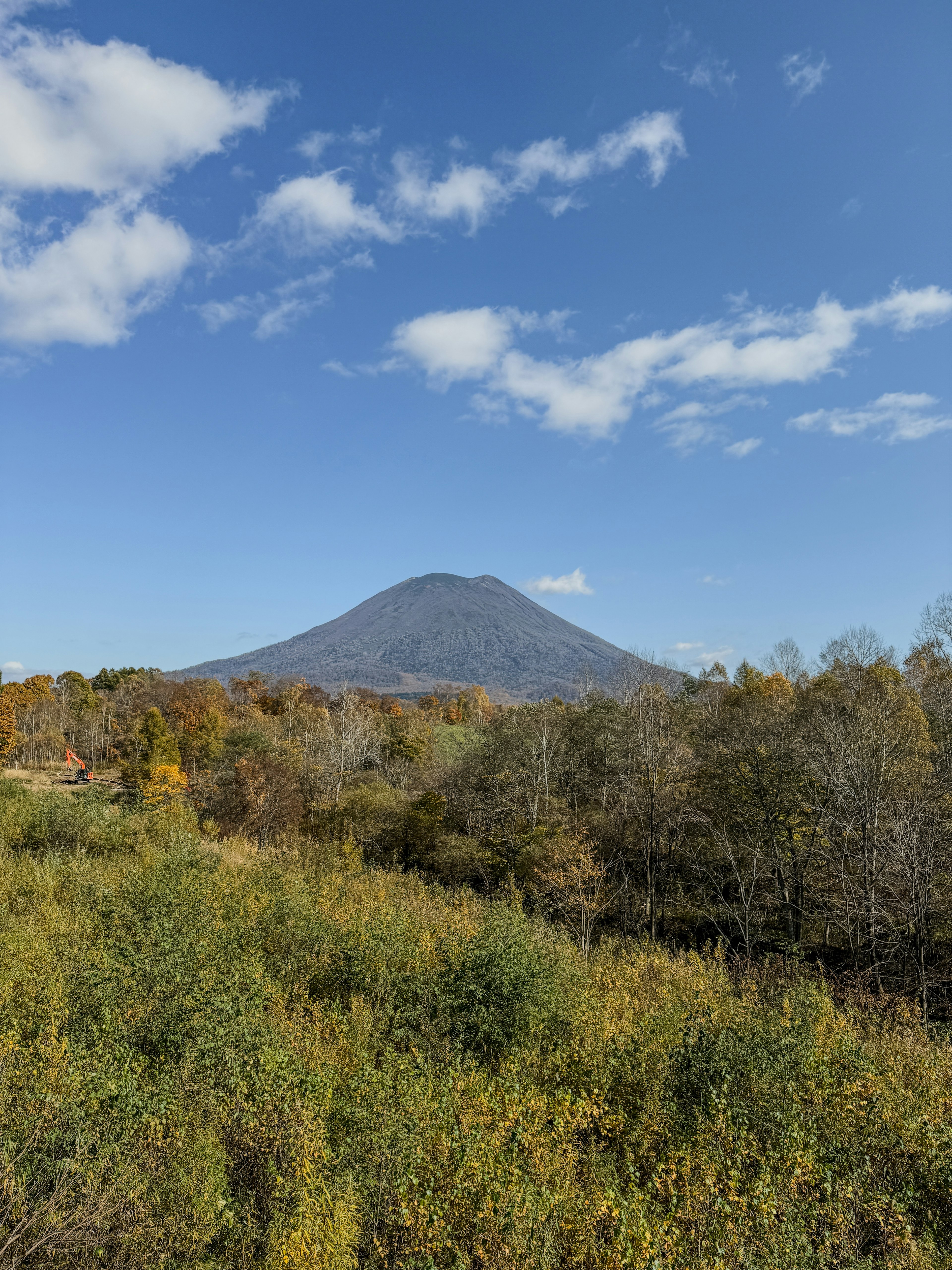 Pemandangan indah gunung dengan langit biru dan awan serta dedaunan musim gugur