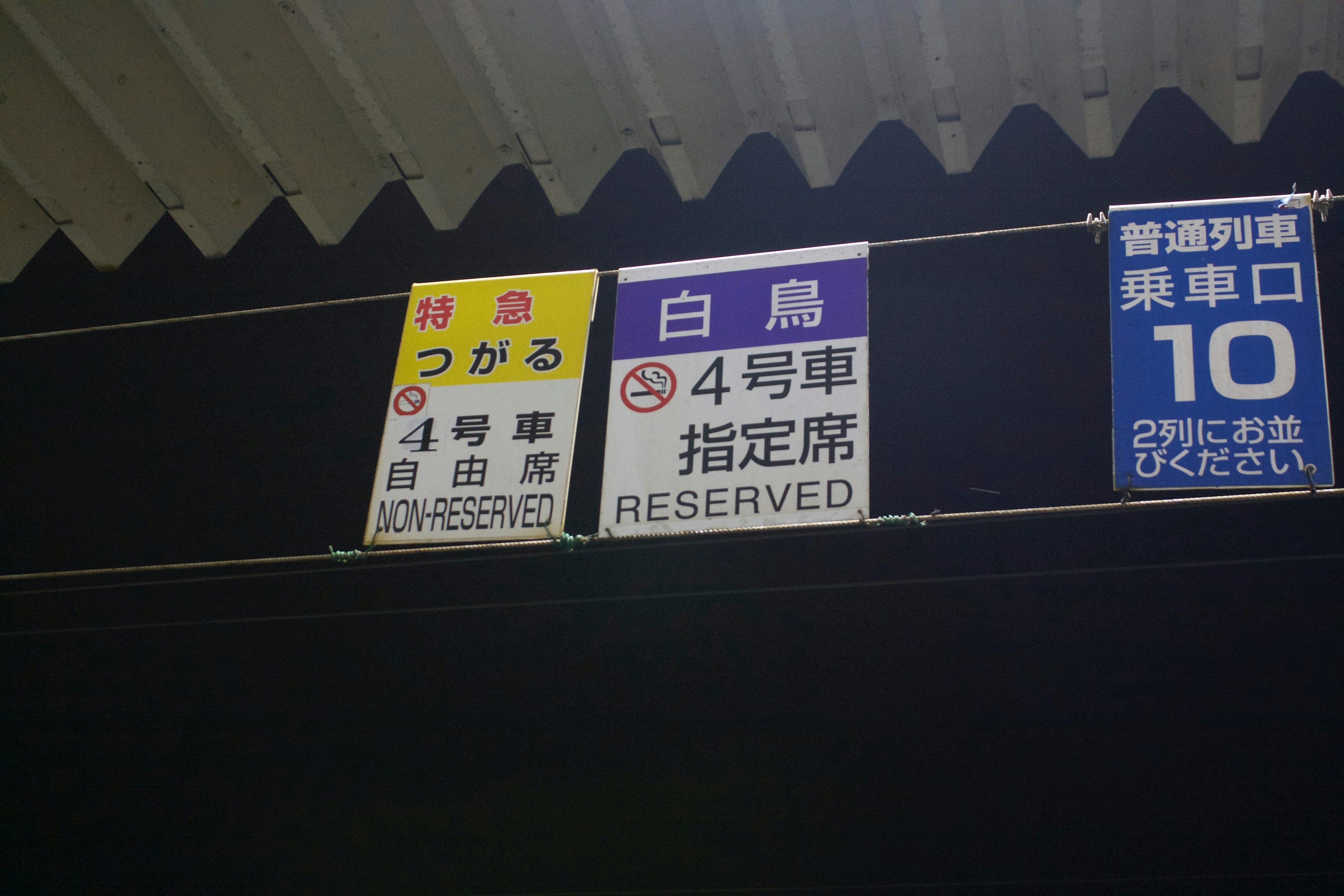 Carteles en una estación de tren que muestran información sobre asientos reservados