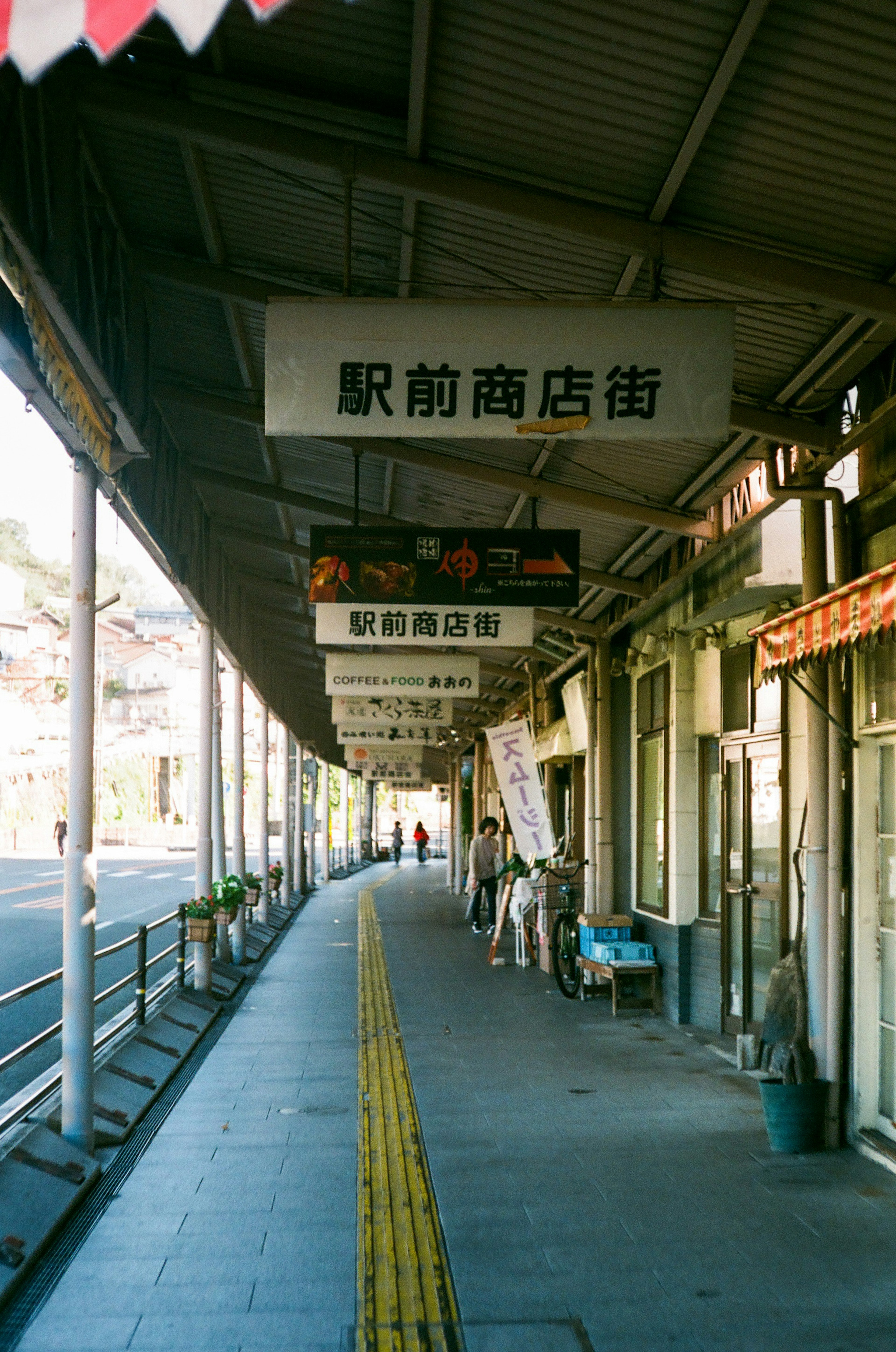 駅前商店街の看板と歩道の風景