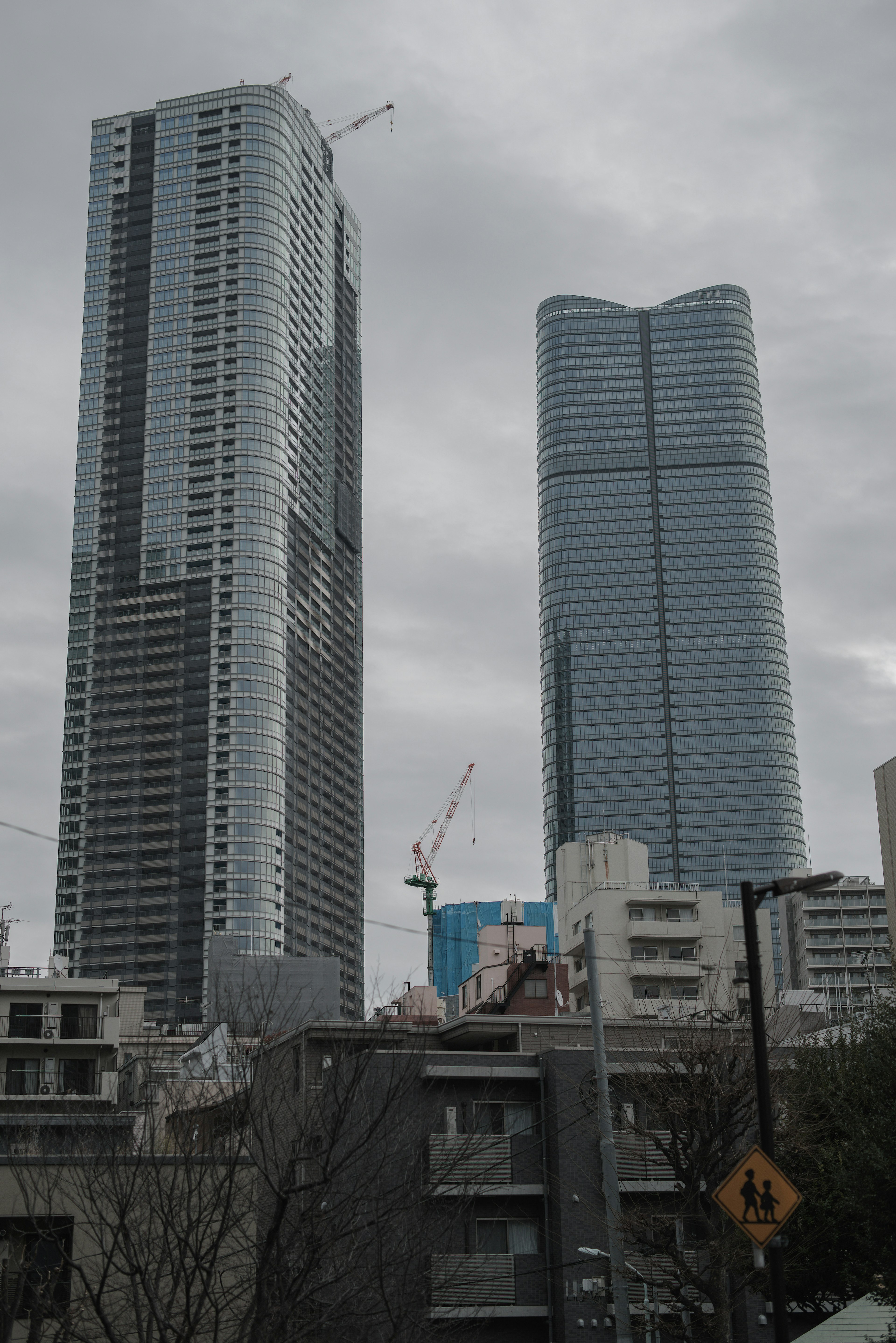 高層ビルが立ち並ぶ都市の景観 複雑なデザインの二つのビルと曇り空