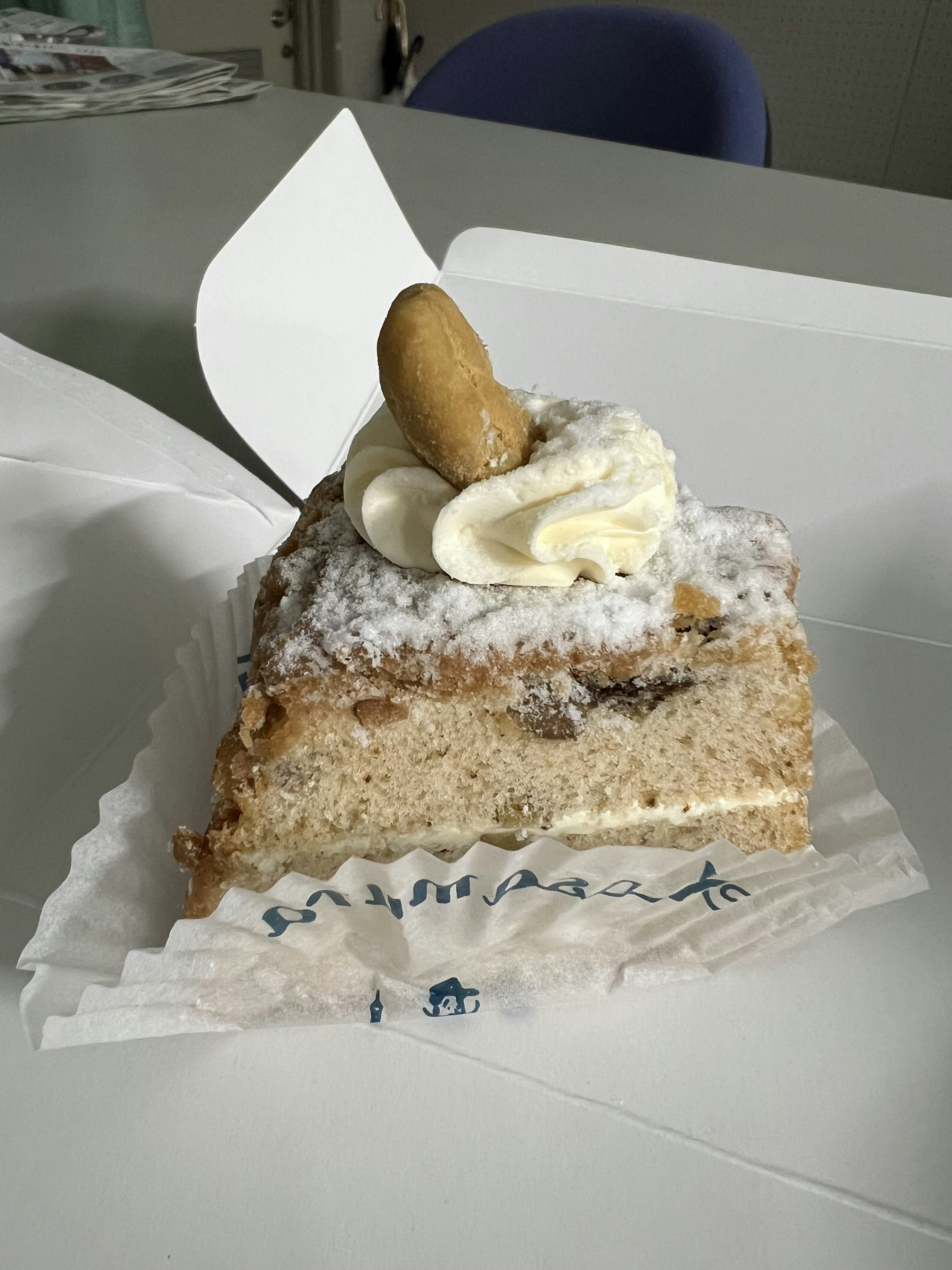 Une part de gâteau garnie de crème et d'une cacahuète