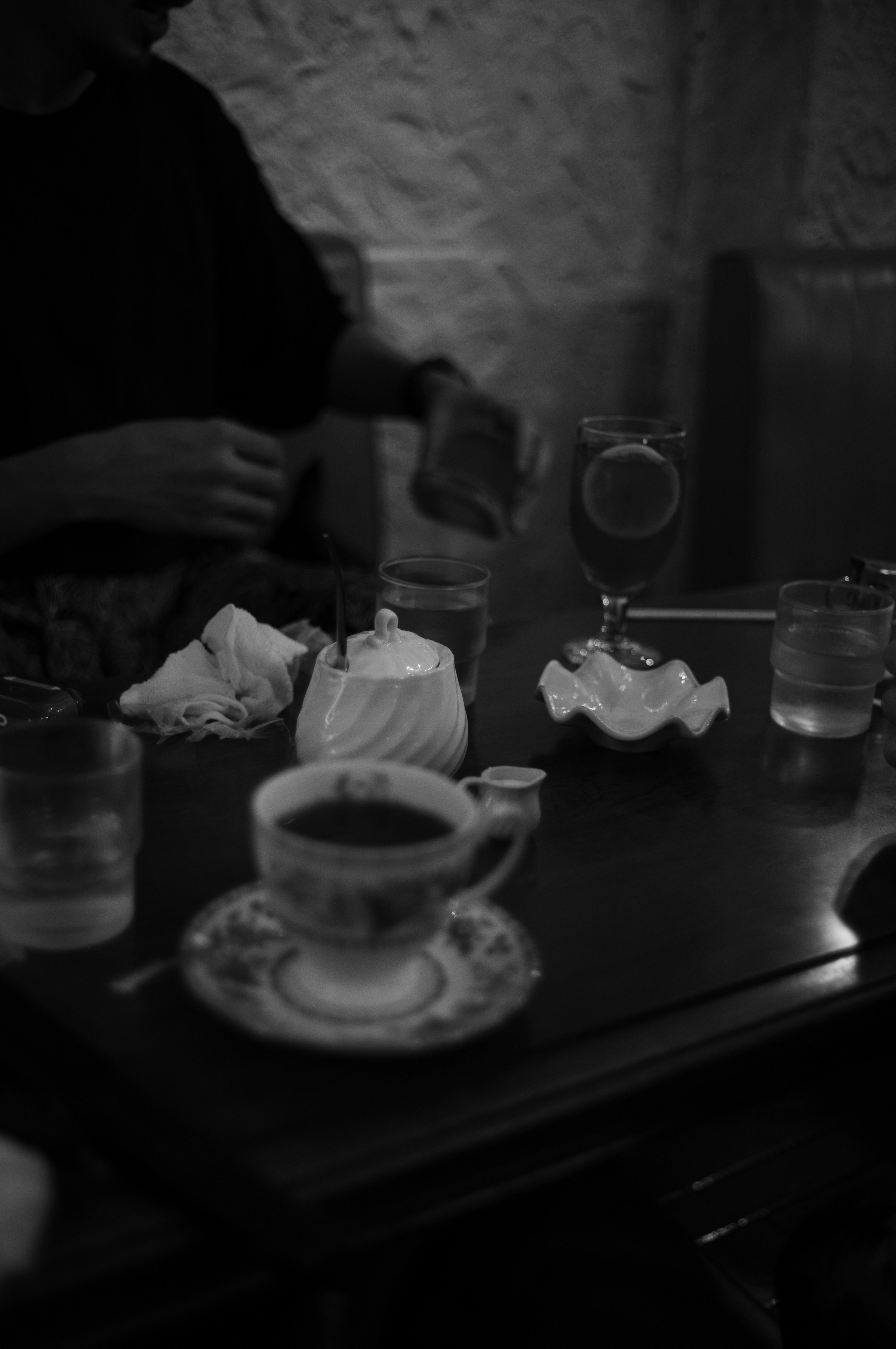 Black and white scene of a café with a teapot and cup on the table