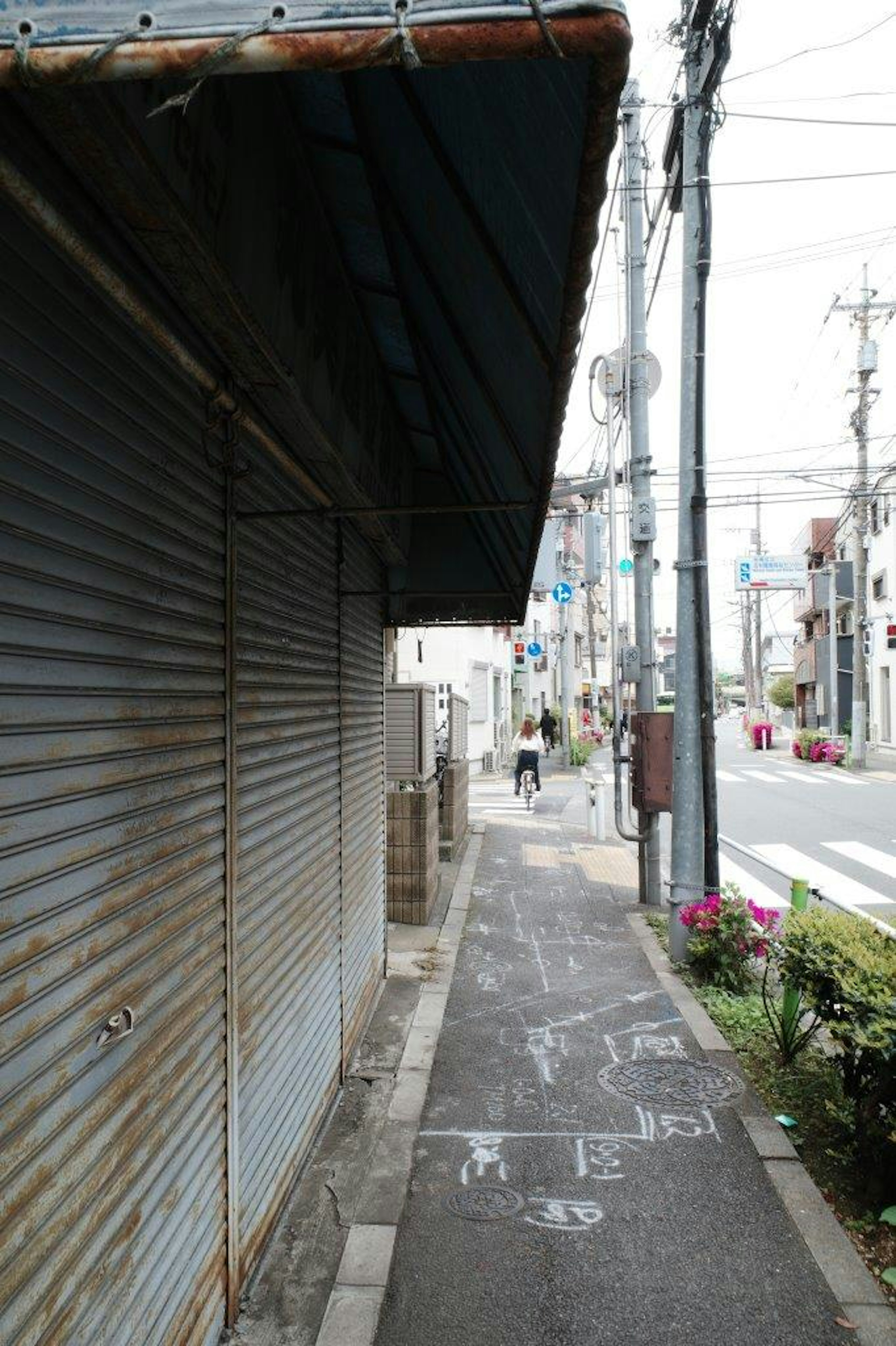 古い店舗のシャッターと歩道の風景