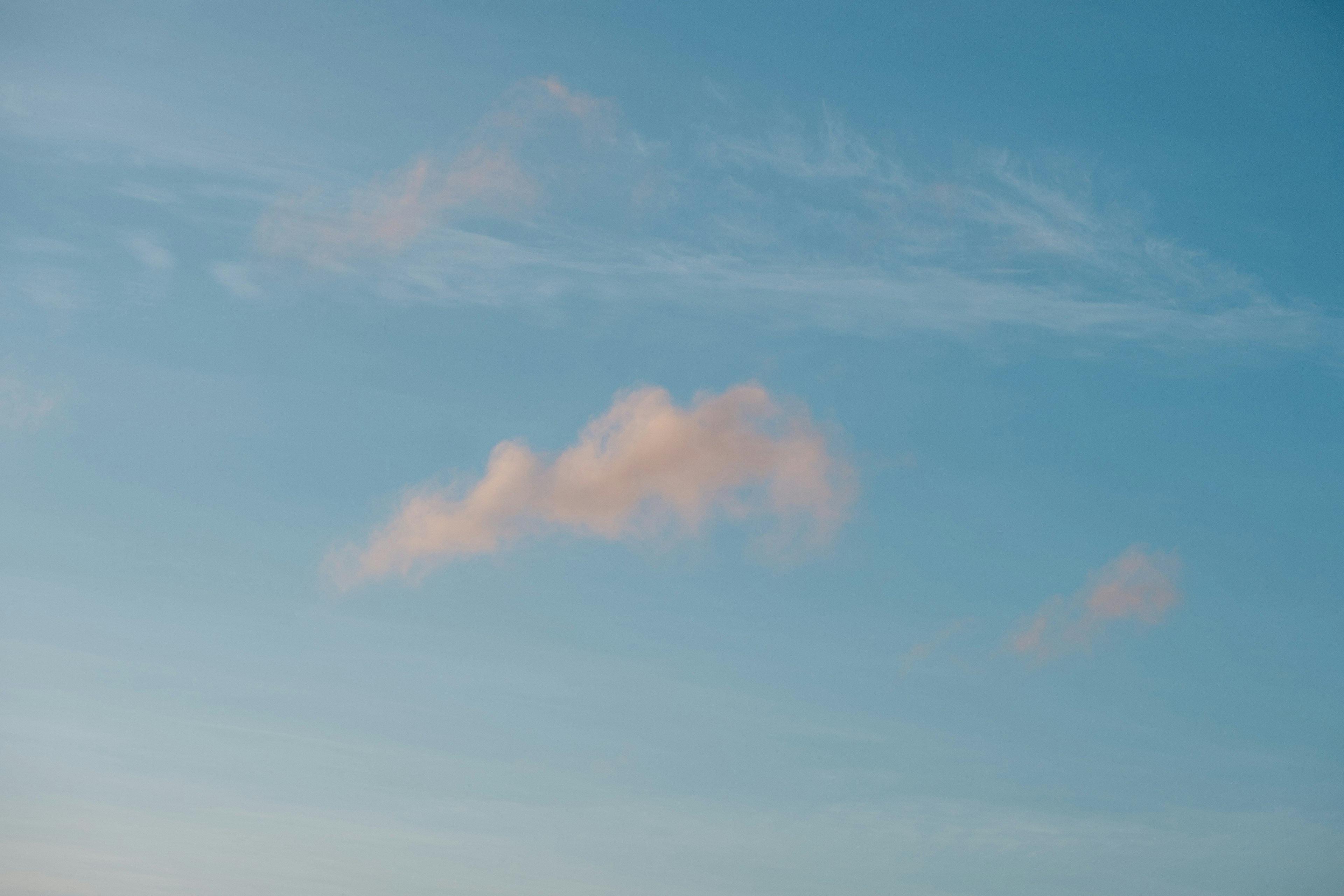 淺粉色雲彩漂浮在晴朗的藍天