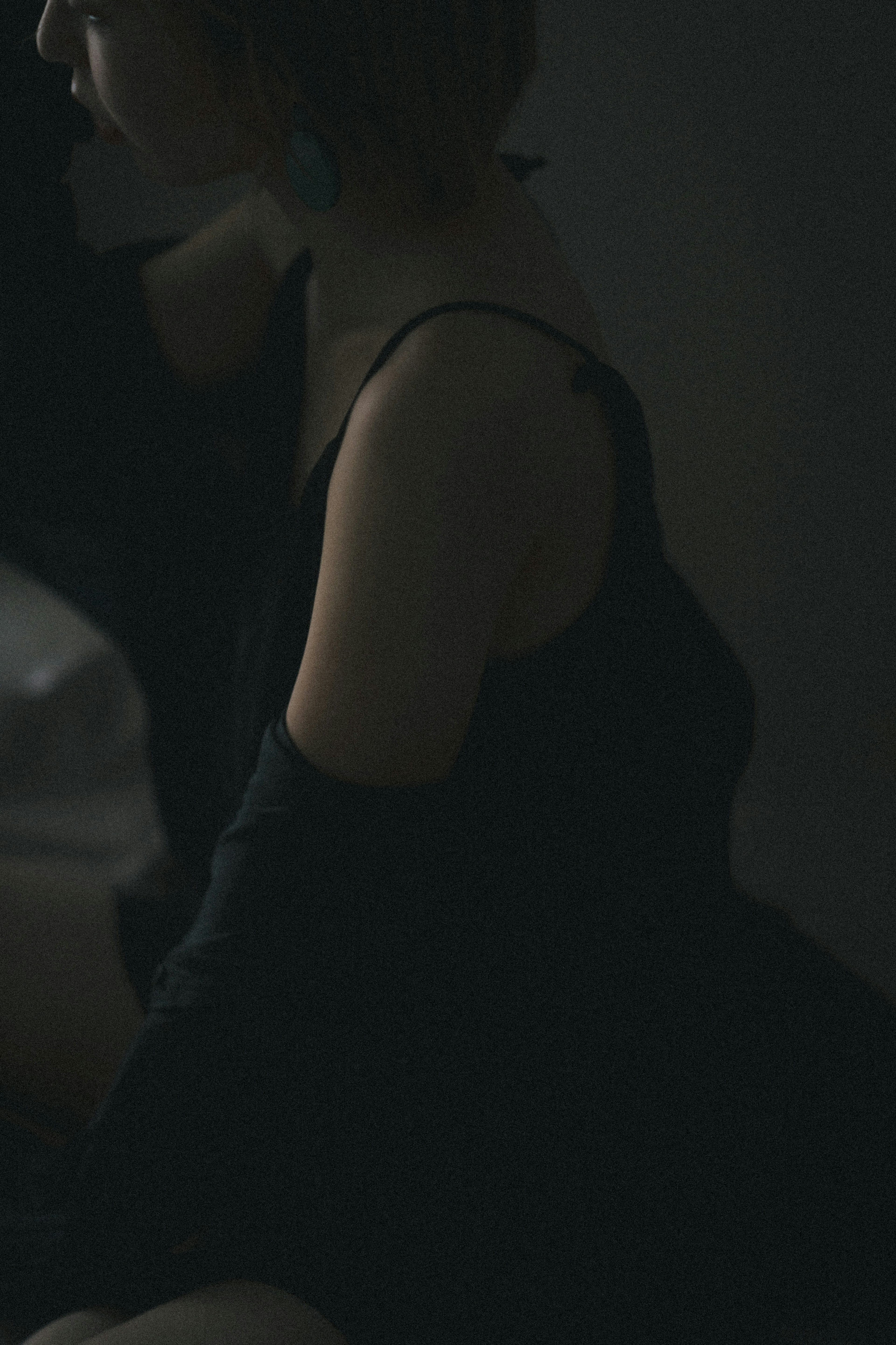 Silhouette of a woman in a dark room wearing a black outfit