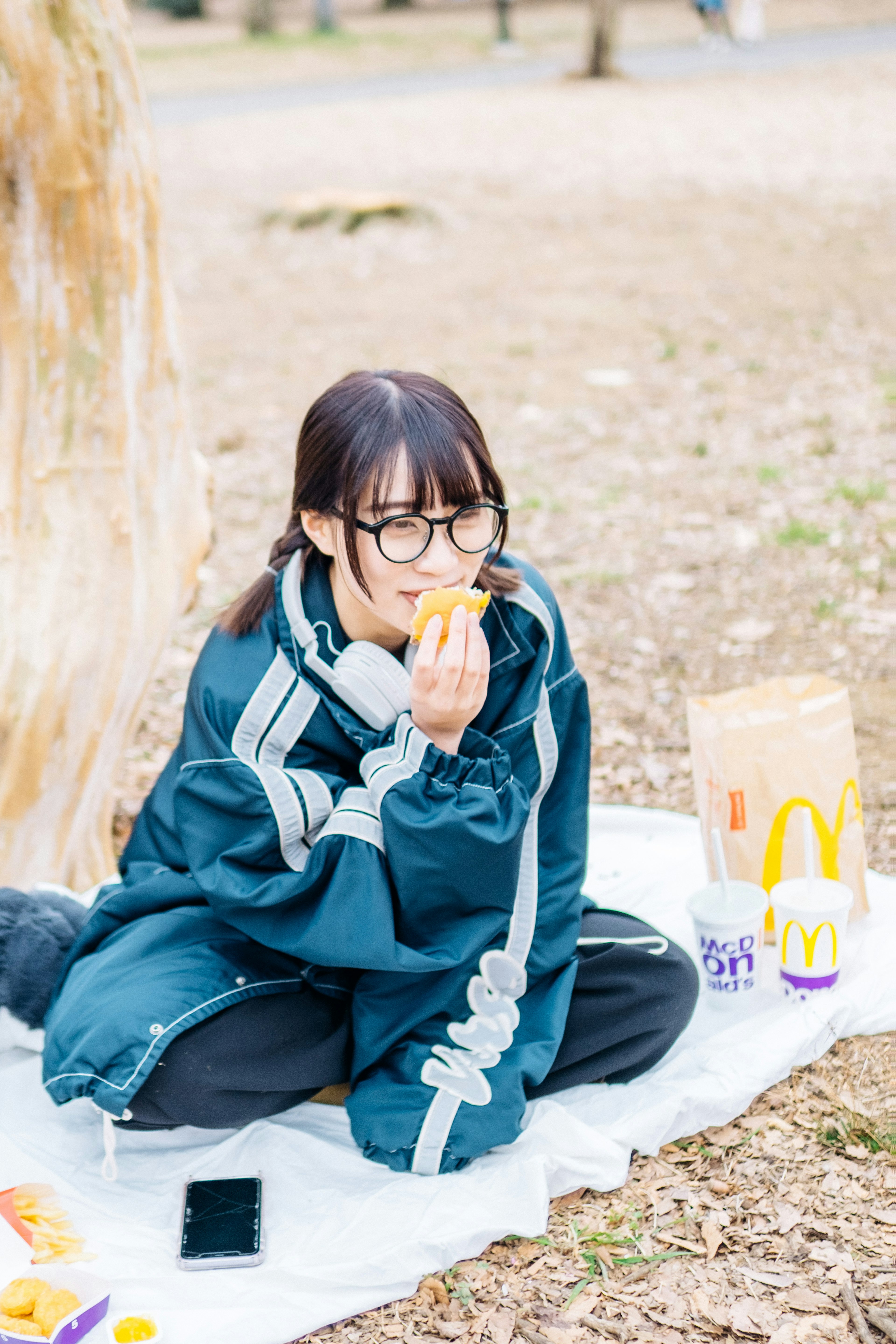 公園で食べ物を楽しむ少女が青い服を着ている