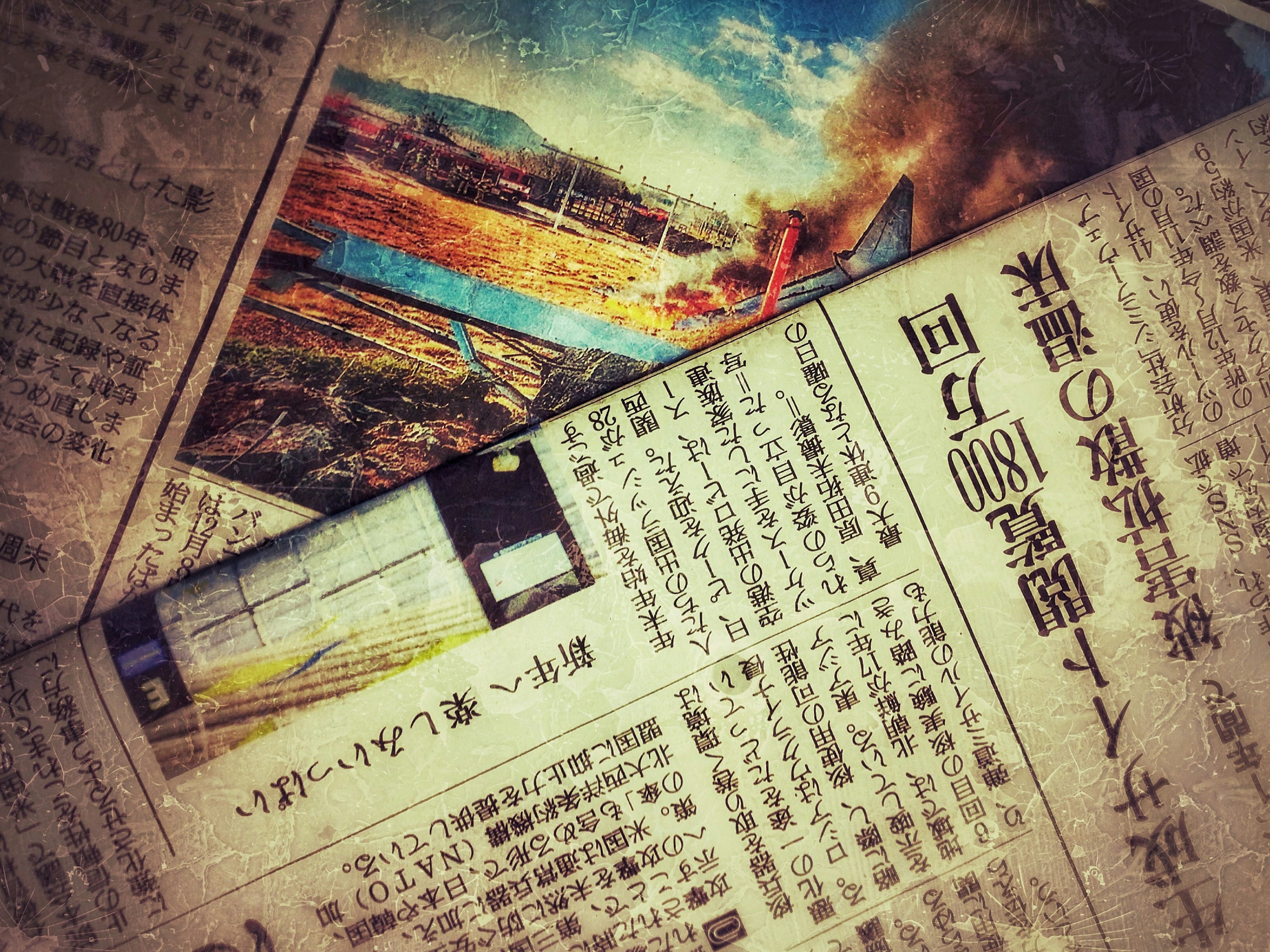 新聞のページが重なり合い、風景の写真が見える