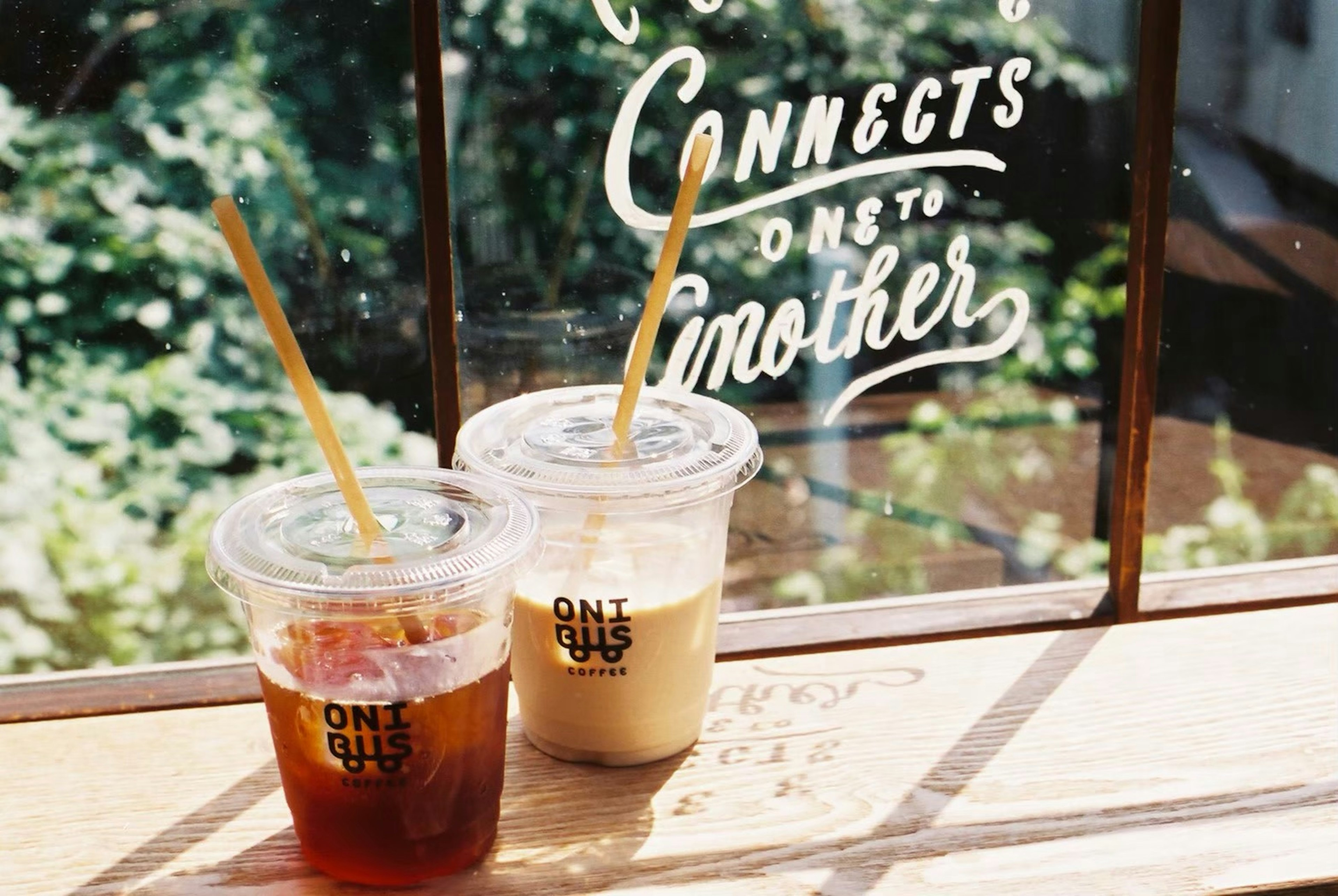 Image of iced coffee and iced latte in clear cups on a wooden table