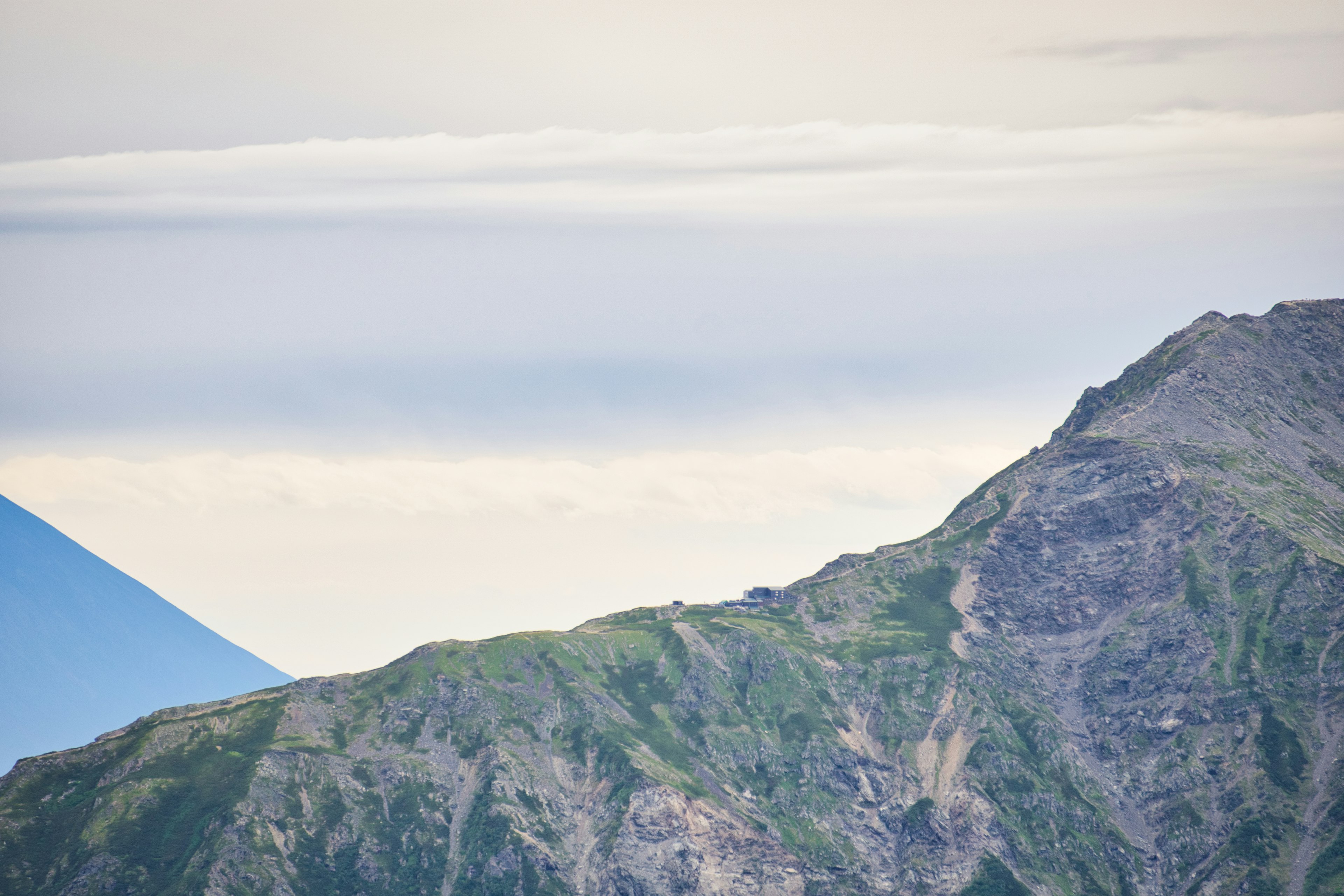 Una vista panoramica di una pendice montuosa verde sotto un cielo nuvoloso