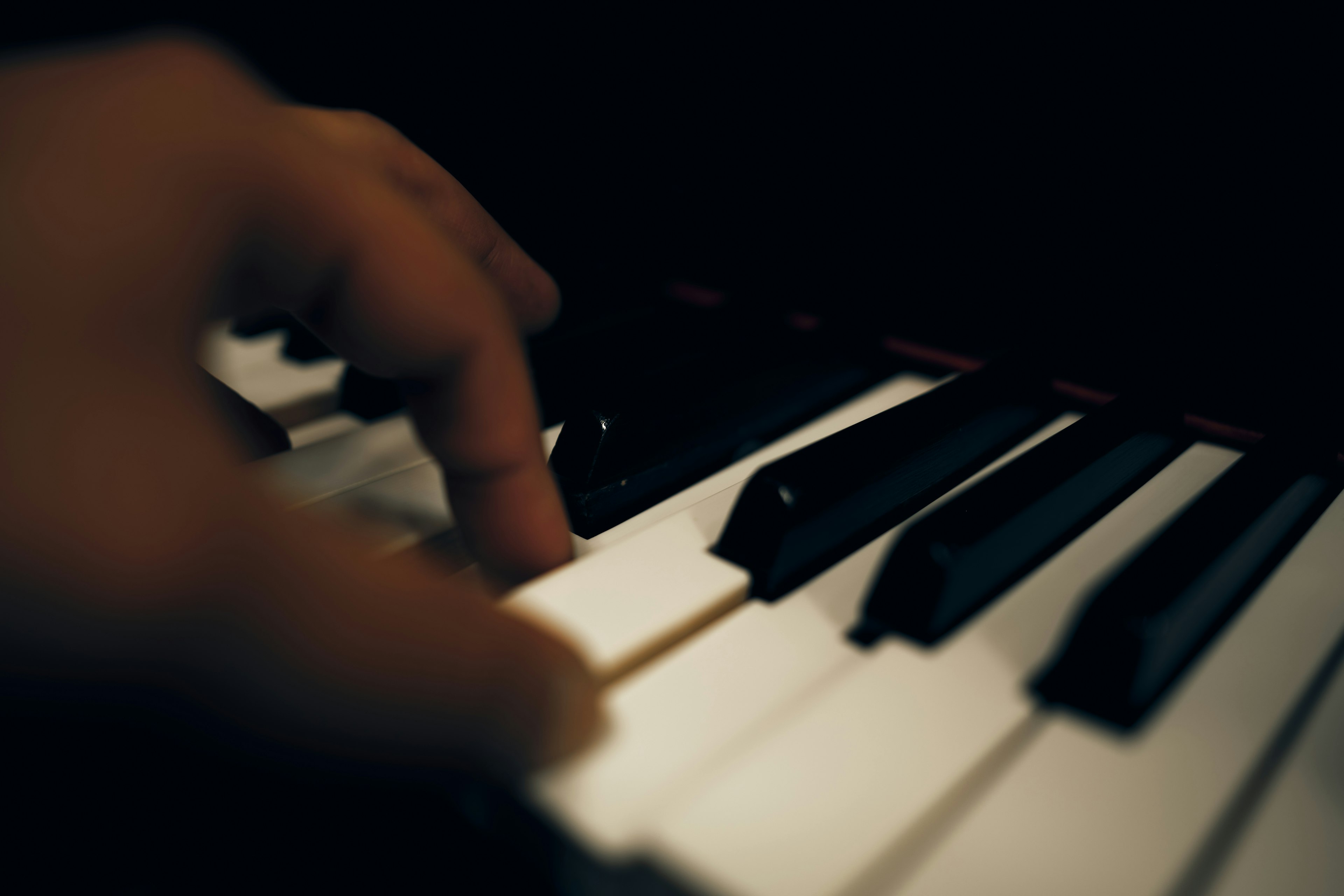 Close-up of a hand playing piano keys