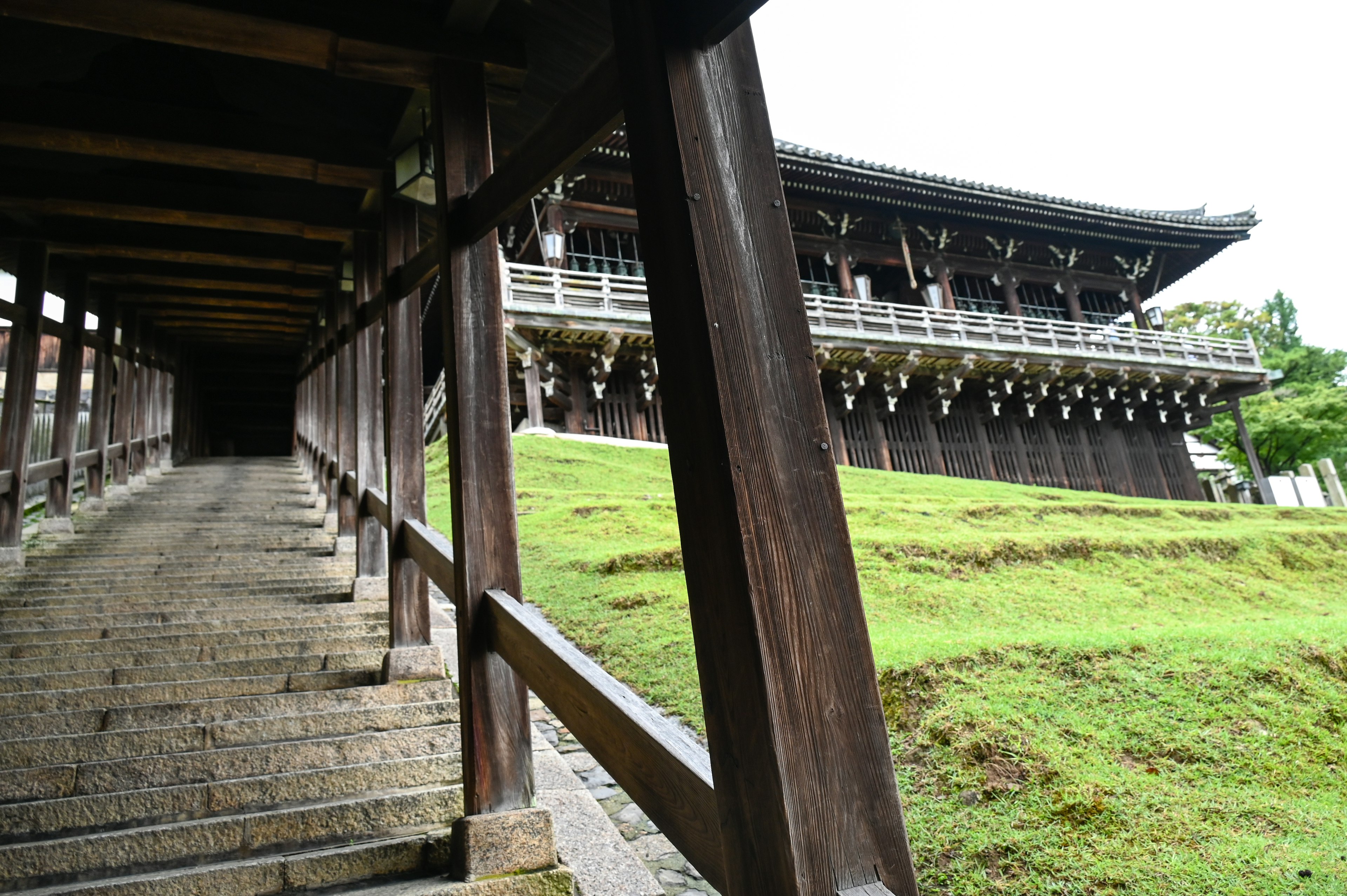 Wooden stairs leading to a traditional building on a green hill