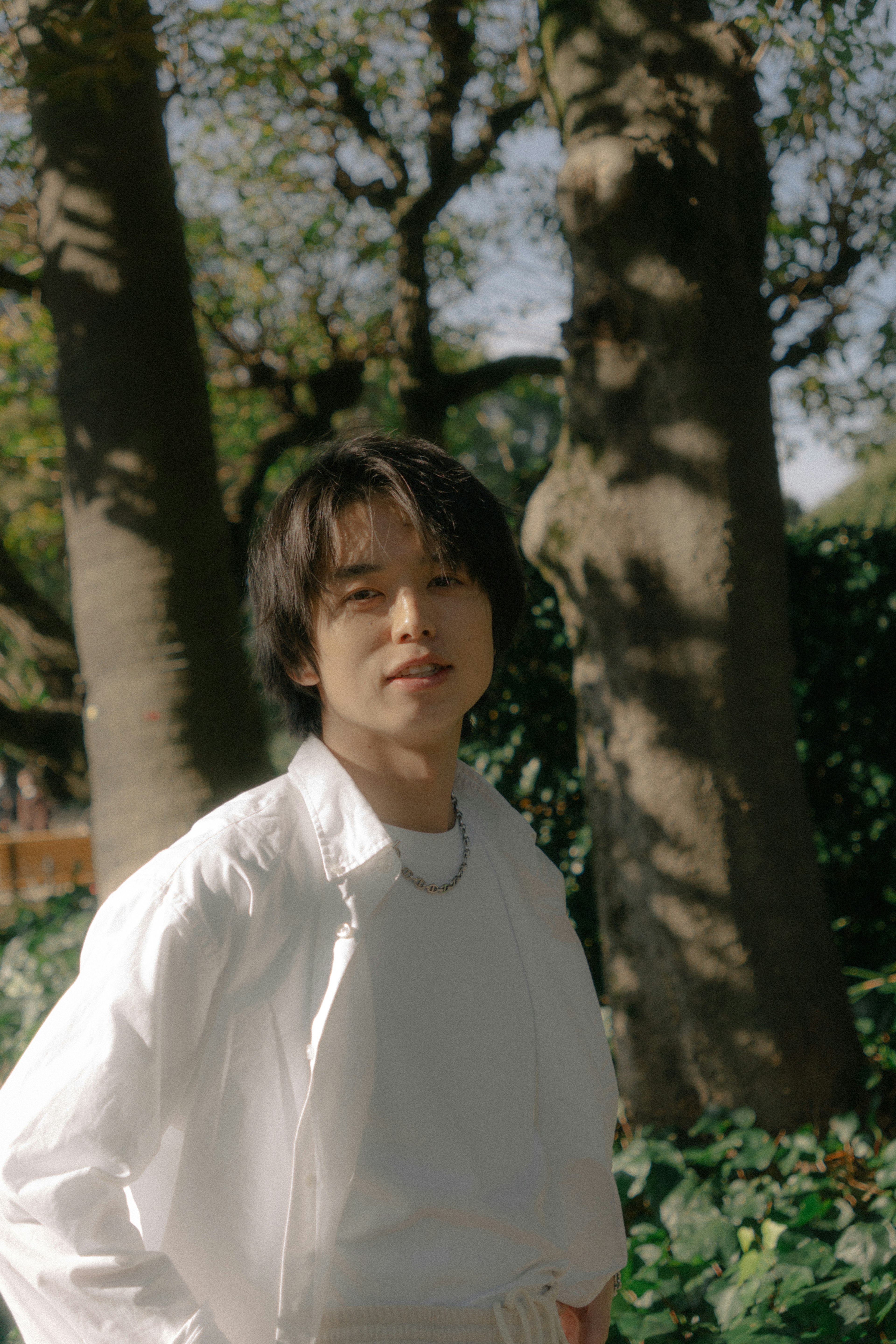 Young man in a white shirt standing in a park