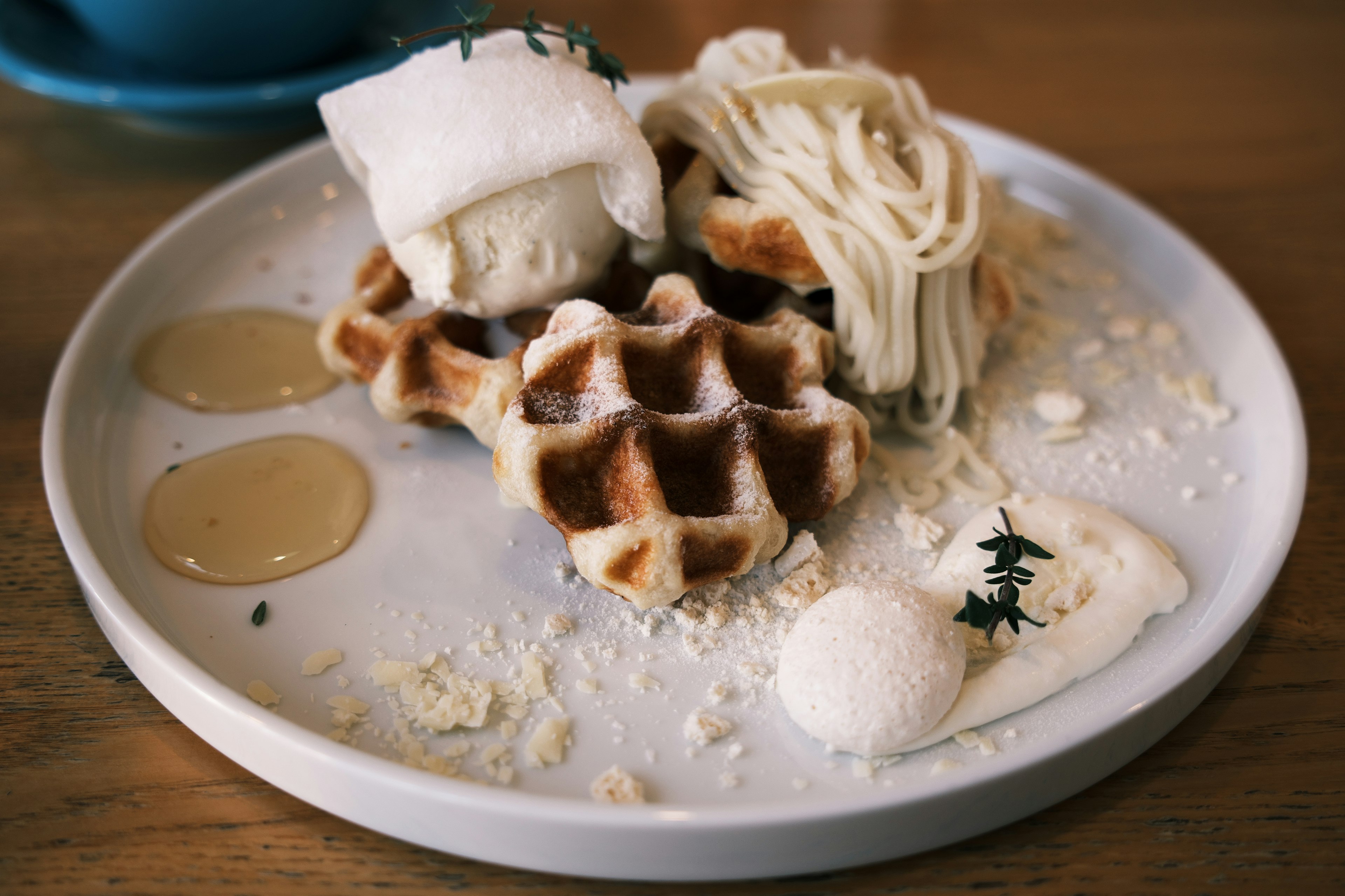 Teller mit Waffeln, Eis und Sahne, übergossen mit Sirup