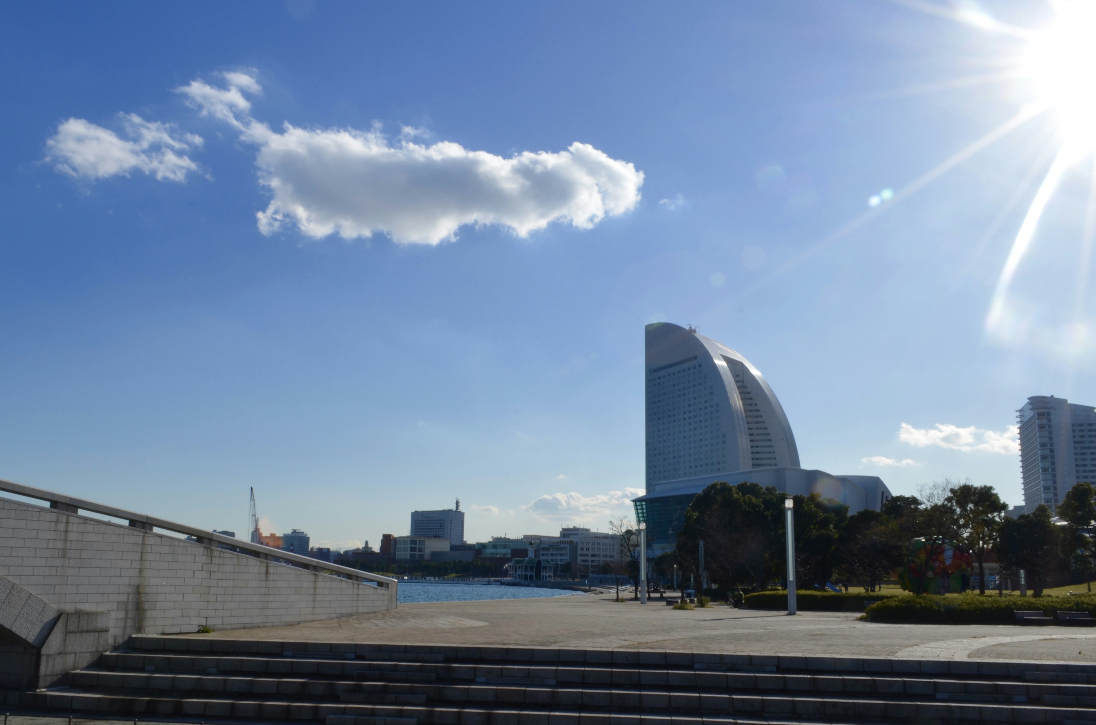 Modern buildings under a clear blue sky with a cloud