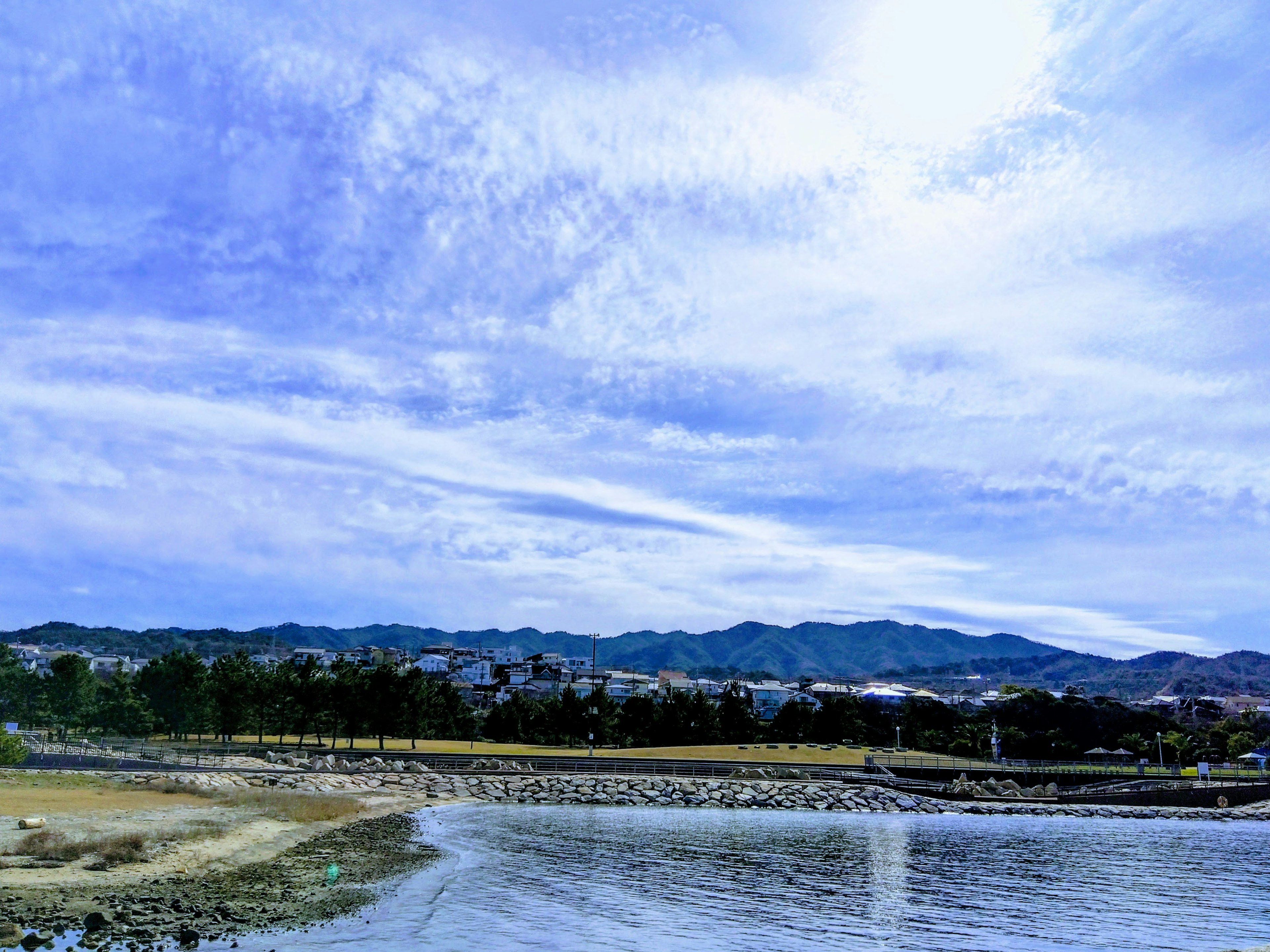 海岸风景，蓝天和云朵，背景有山脉