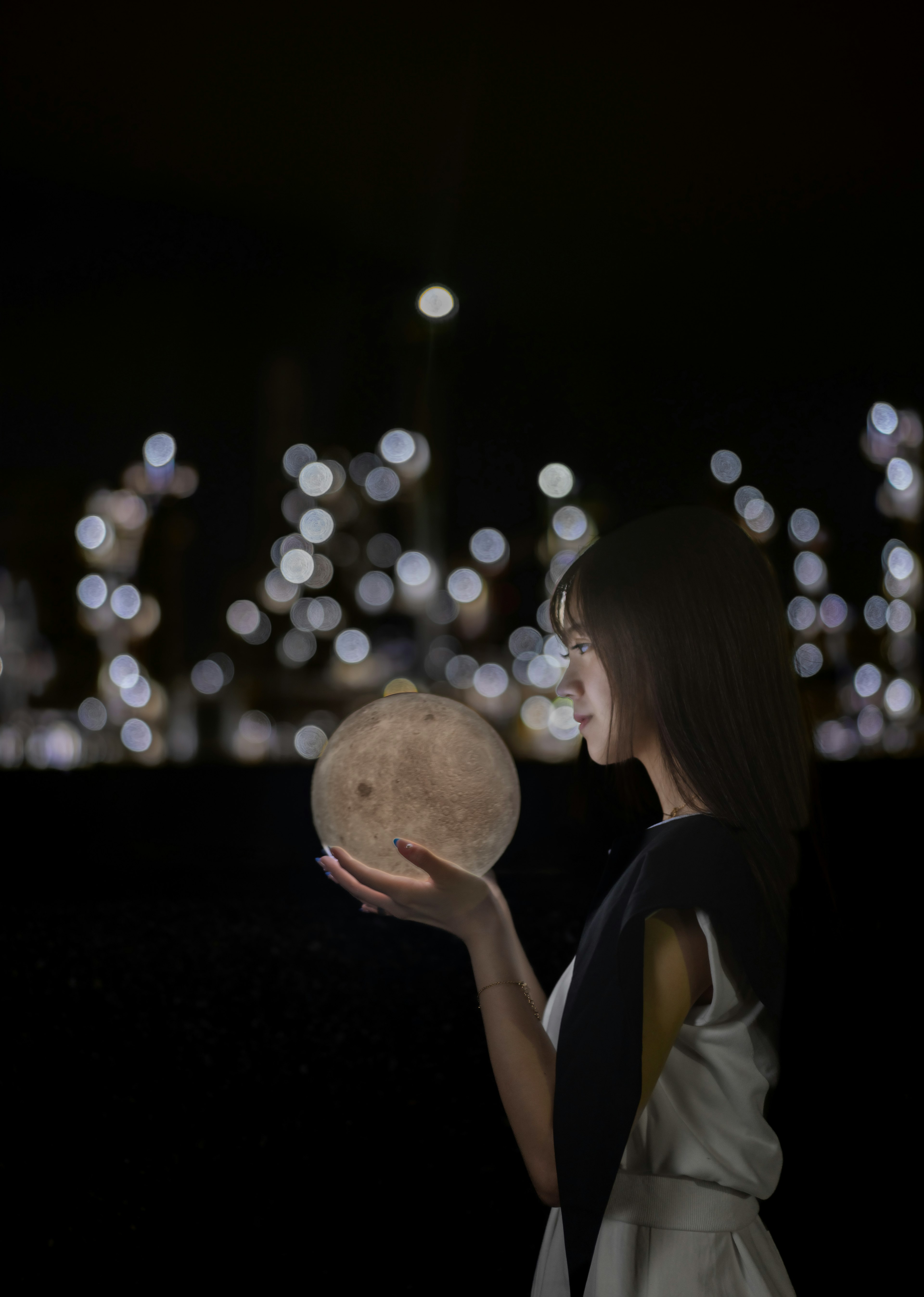 一位女性手持發光球體，背景為模糊的燈光，營造夢幻氛圍