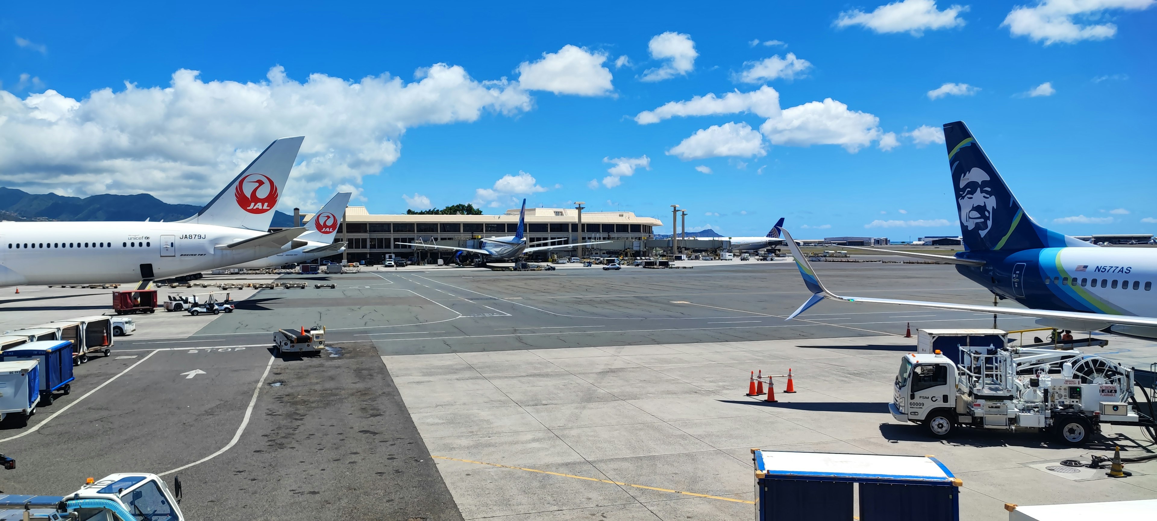 Pesawat terparkir di landasan bandara dengan langit biru